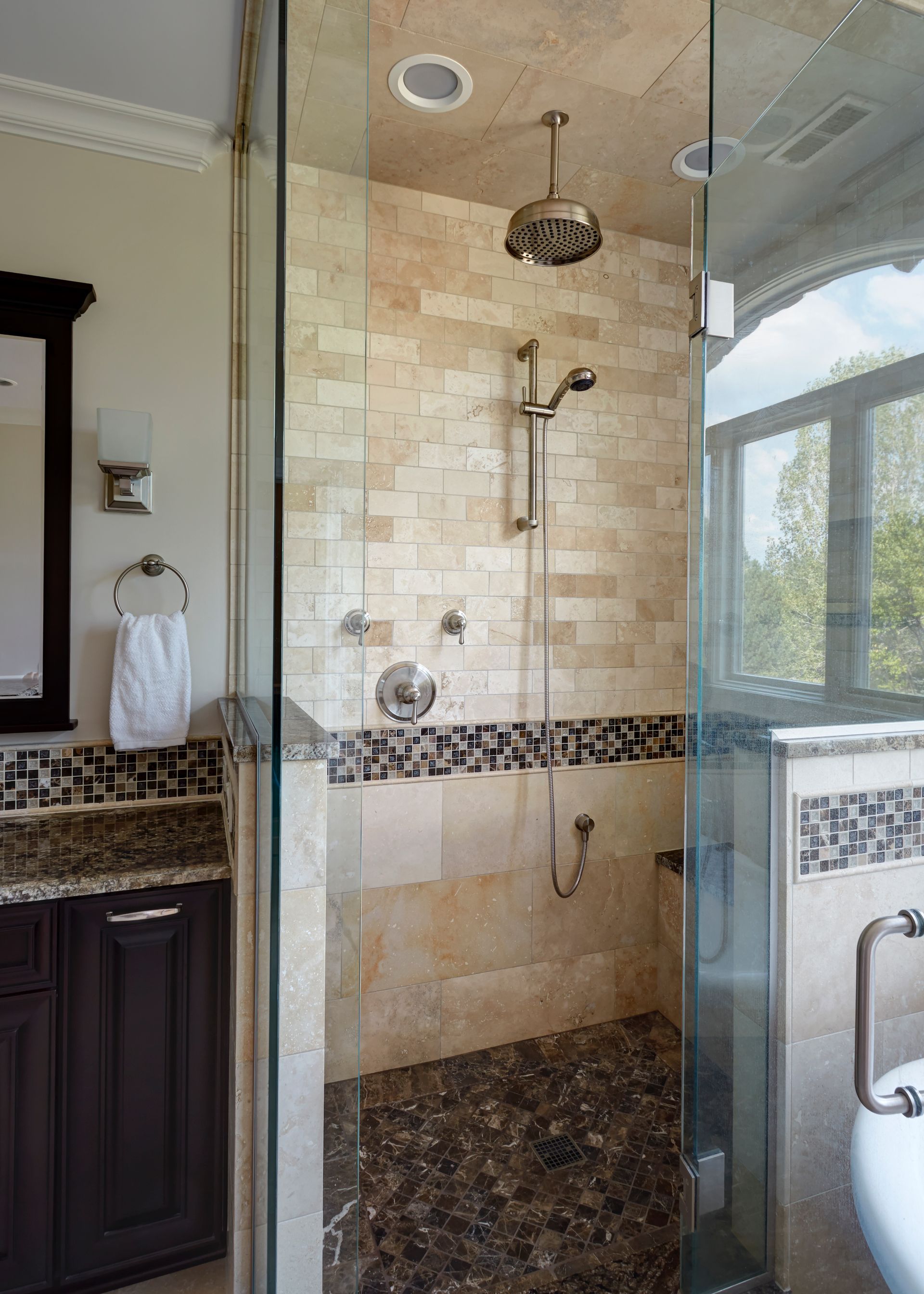 A bathroom with a walk in shower and a sink.