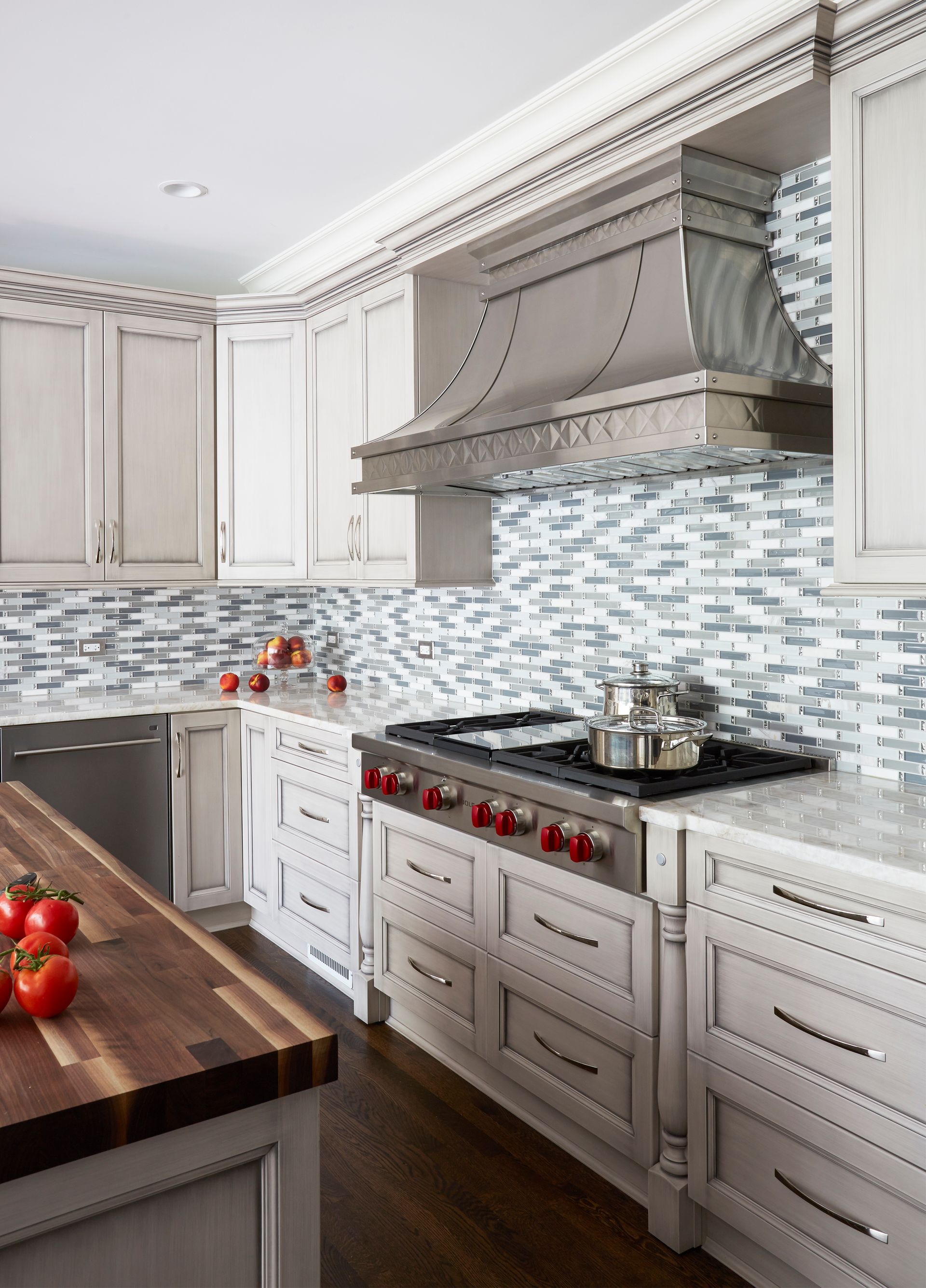 A kitchen with white cabinets and a wooden counter top
