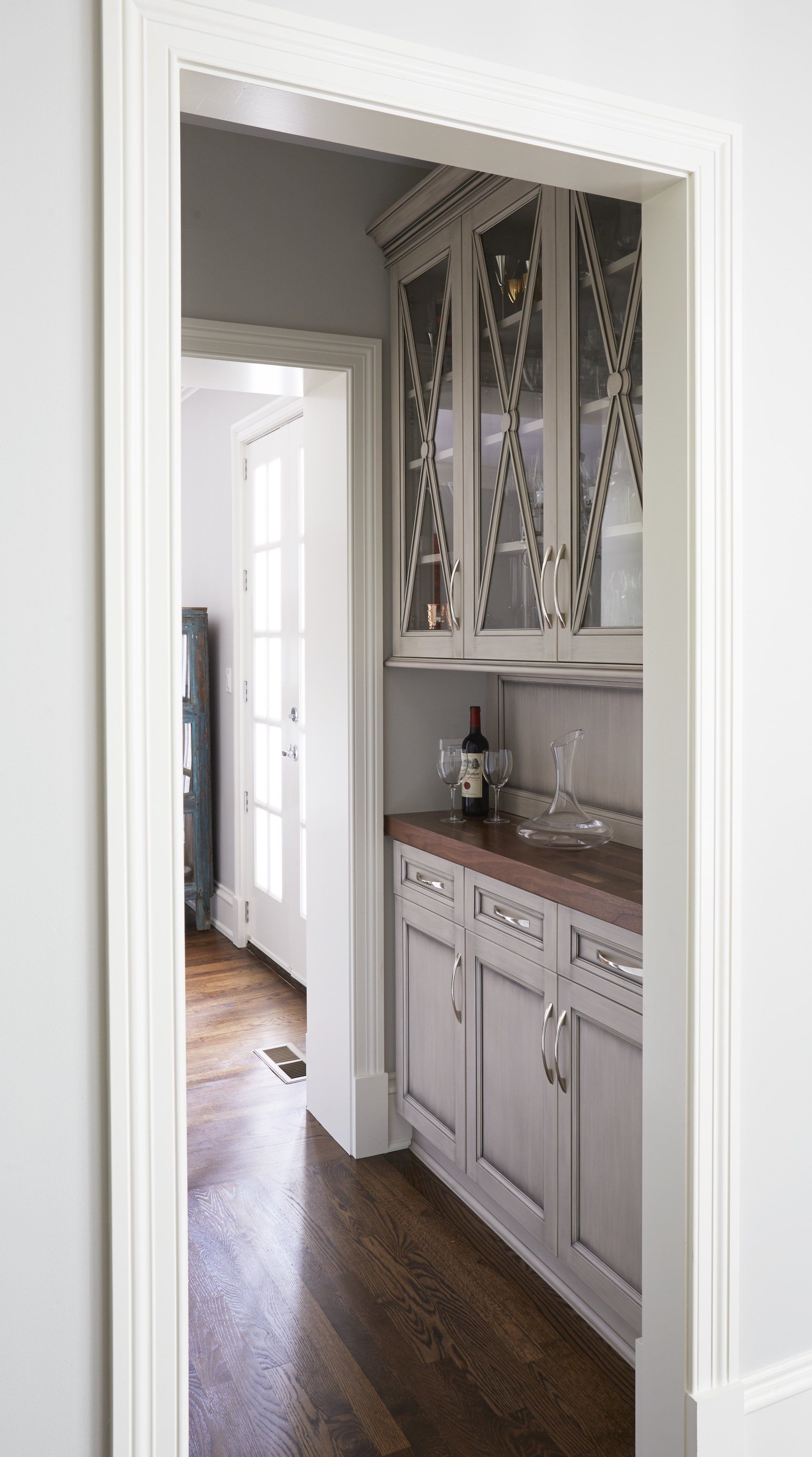 A kitchen with white cabinets and a bottle of wine on the counter.