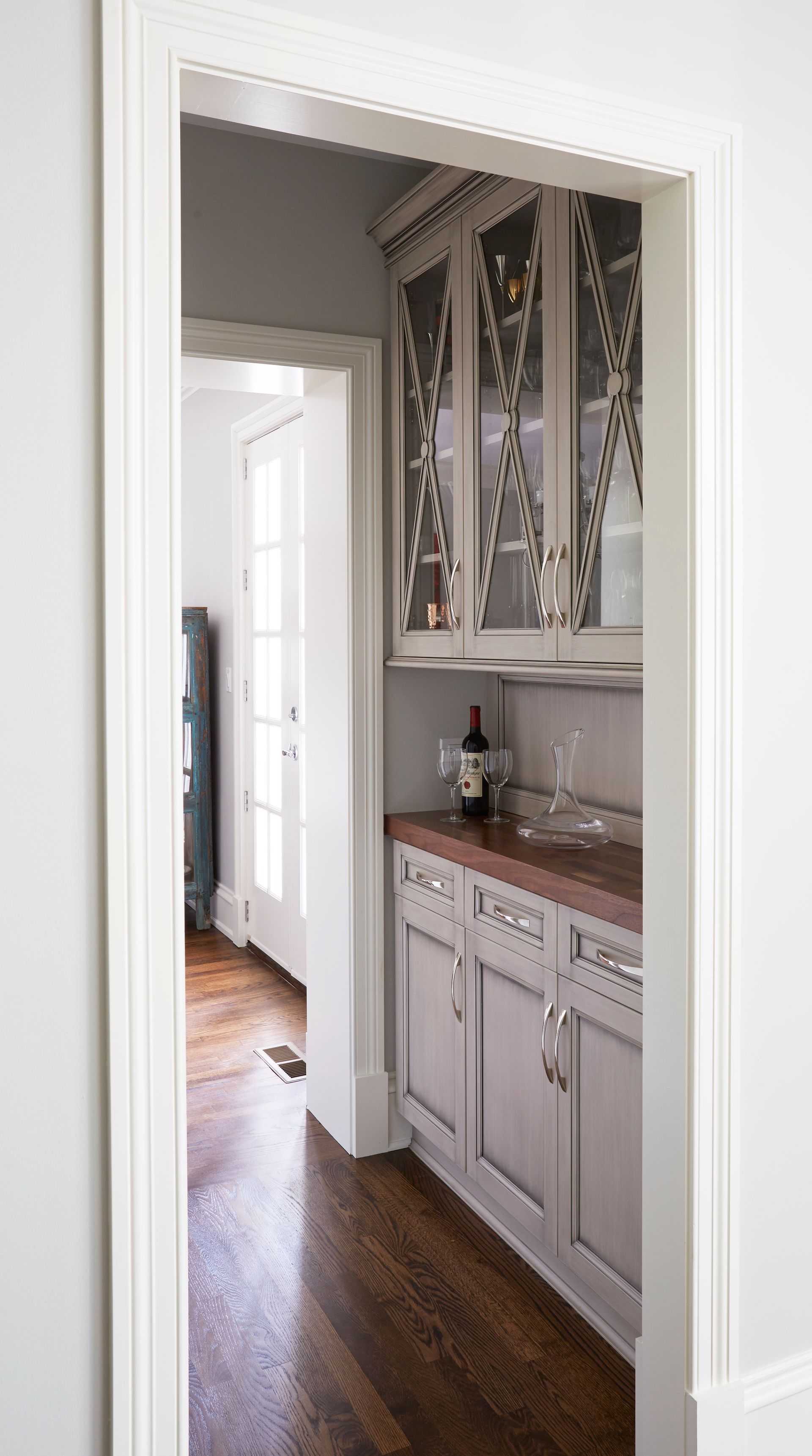 A kitchen with white cabinets and a bottle of wine on the counter.