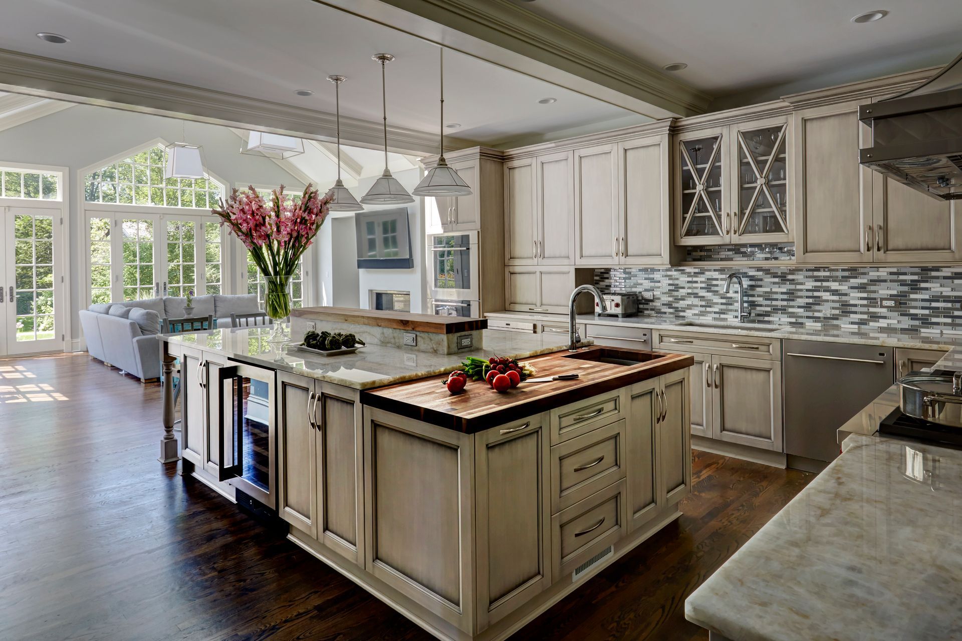 A kitchen with white cabinets and a large island in the middle