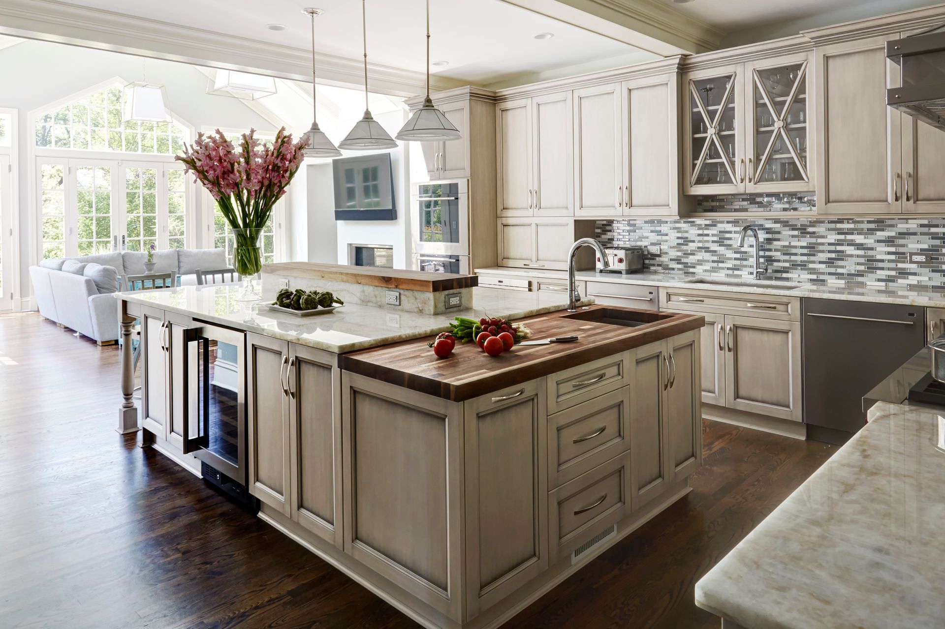 A kitchen with white cabinets and a large island in the middle