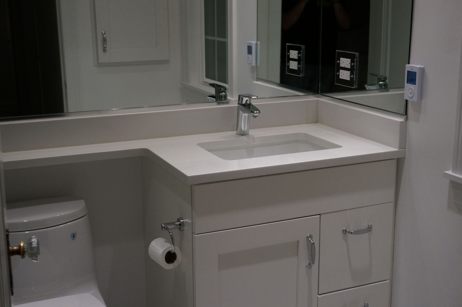 A bathroom with a toilet a sink and a mirror