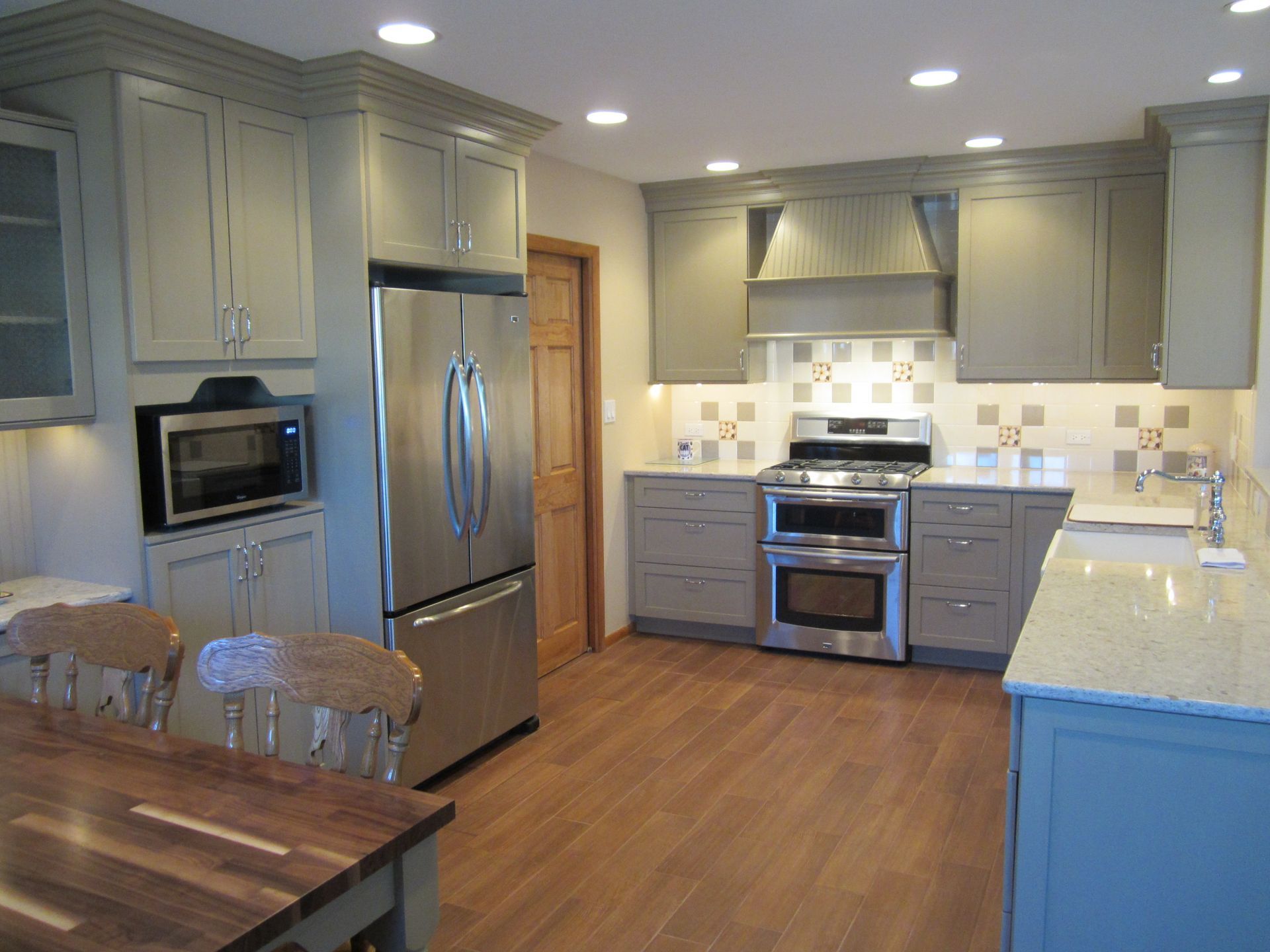 A kitchen with stainless steel appliances and gray cabinets
