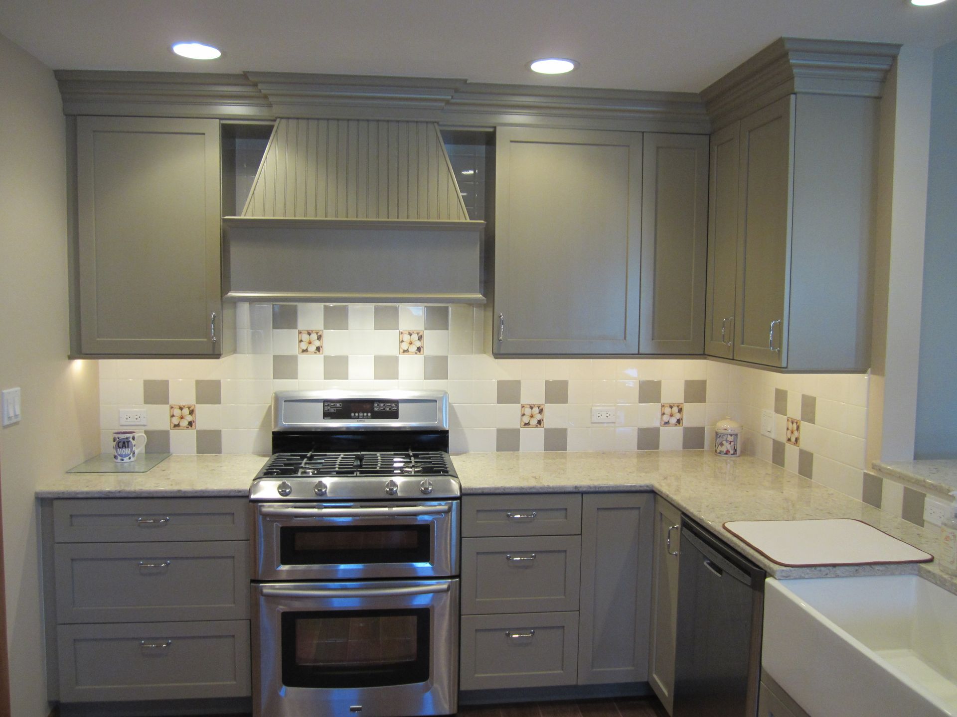 A kitchen with stainless steel appliances and gray cabinets