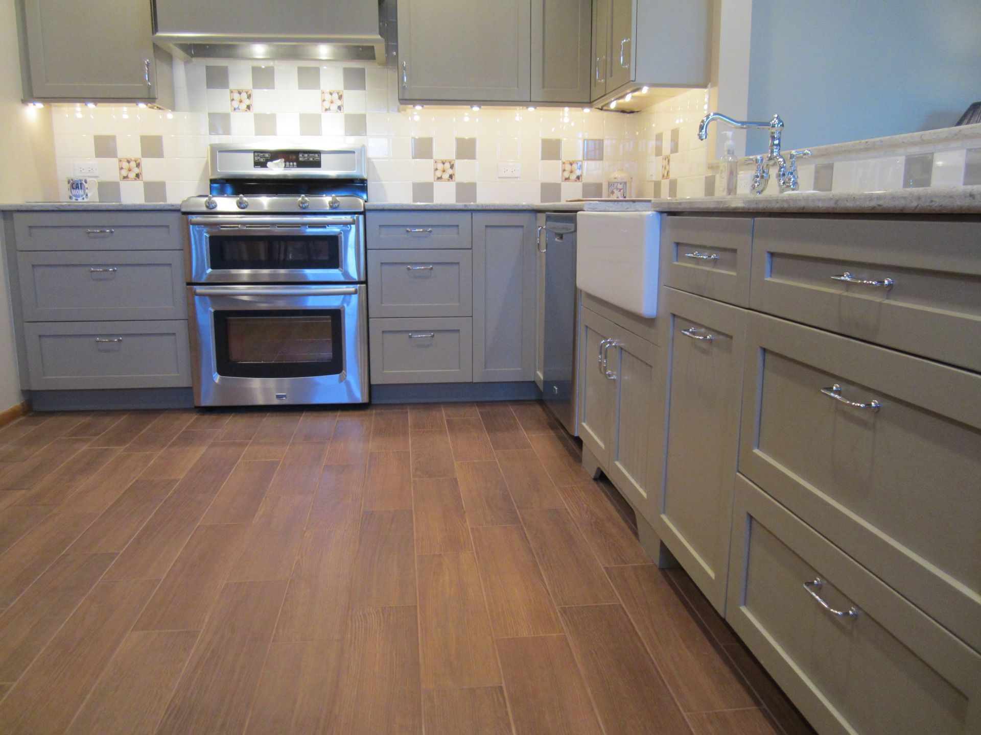 A kitchen with stainless steel appliances and gray cabinets