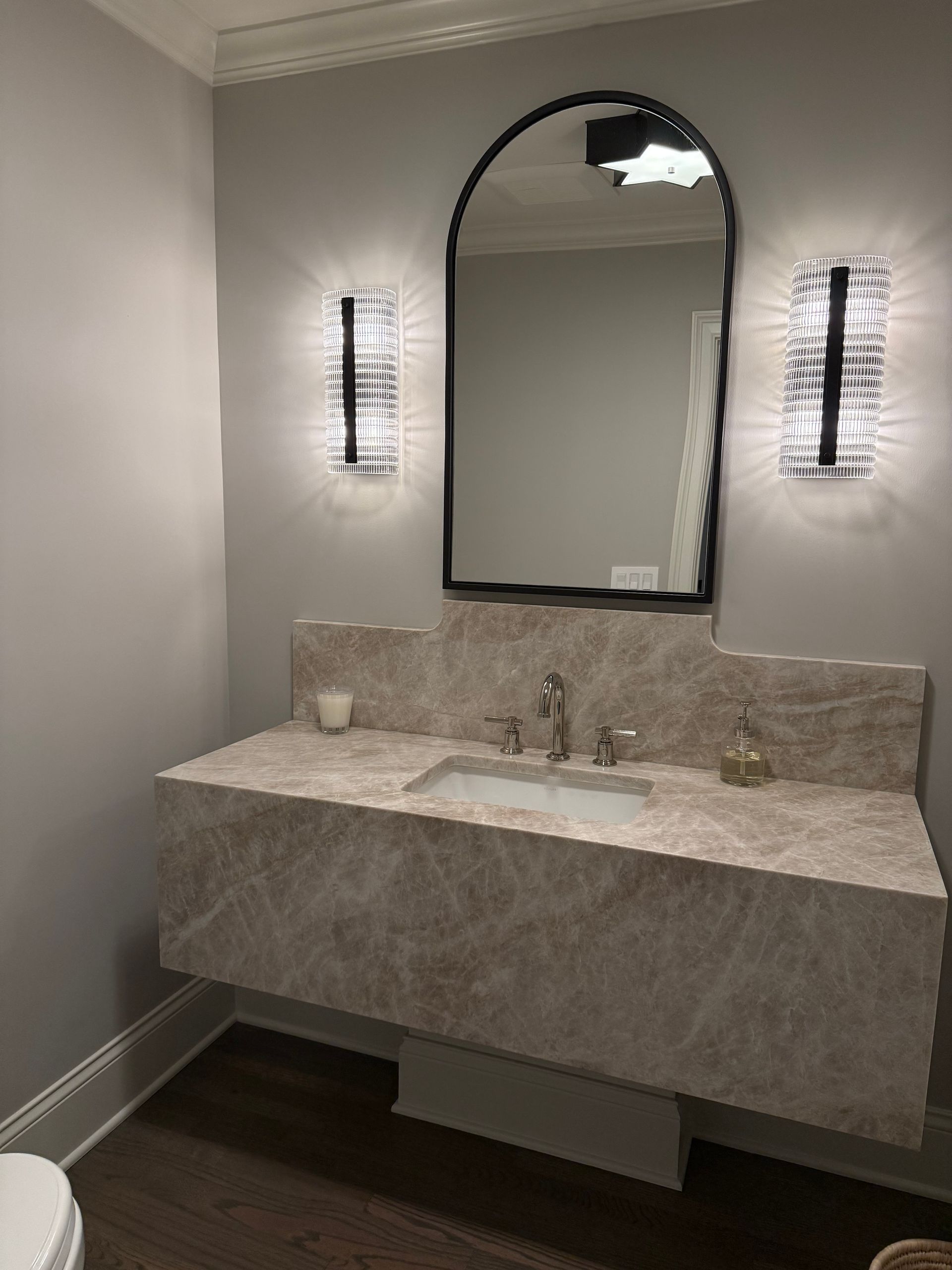 A bathroom with a sink , mirror , and toilet.