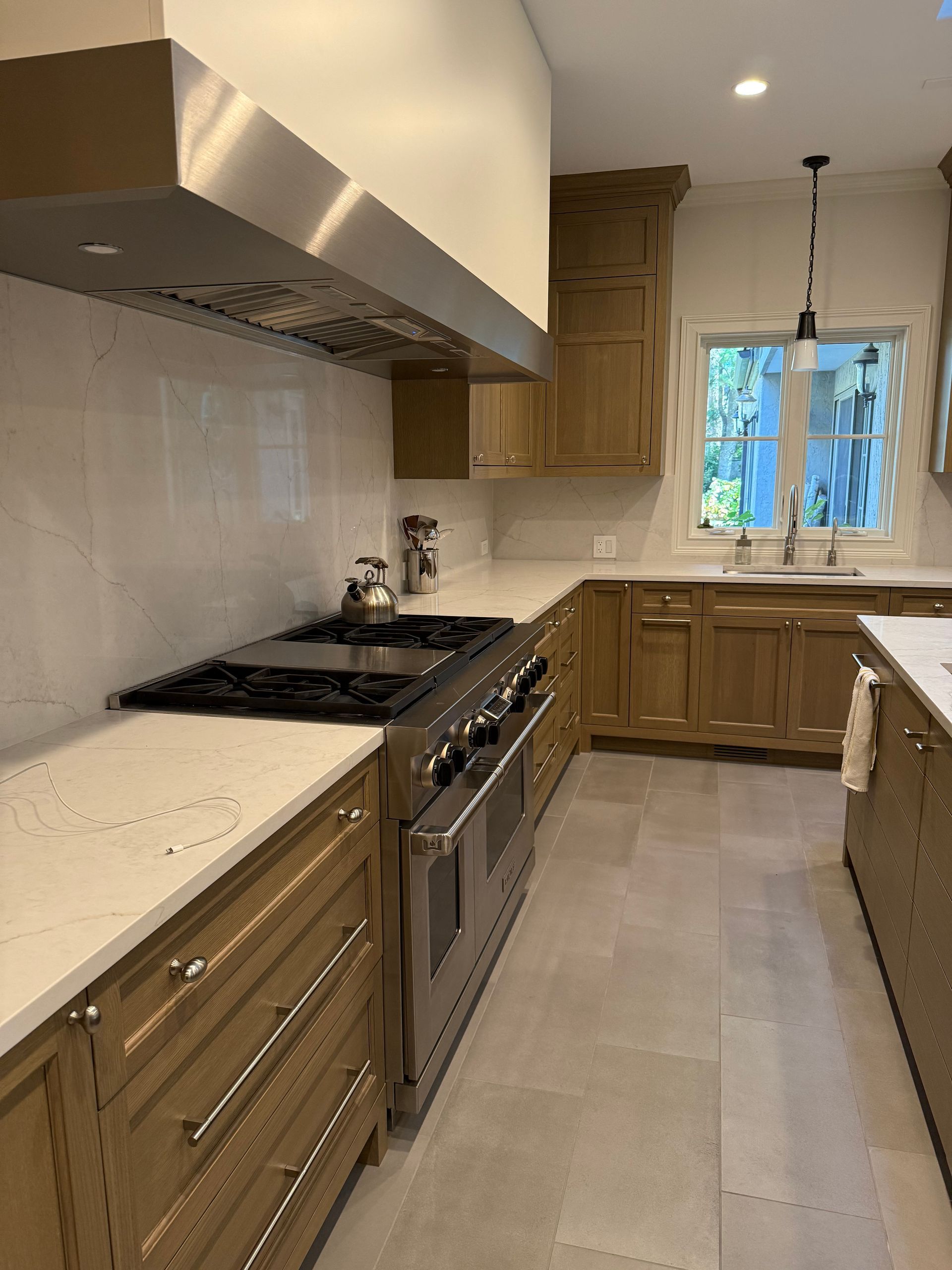 A kitchen with stainless steel appliances and wooden cabinets.