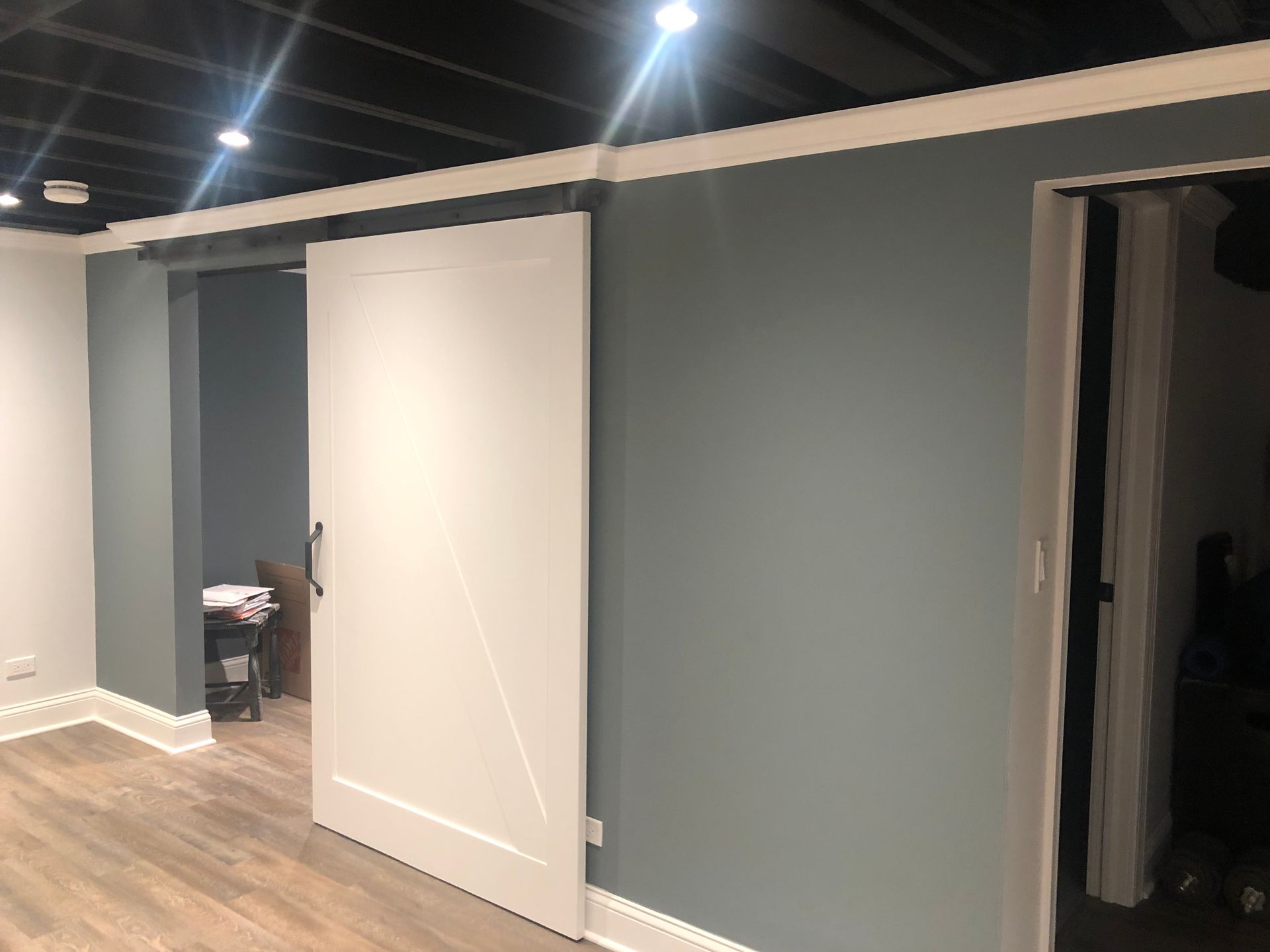 A hallway with a sliding barn door between two rooms.