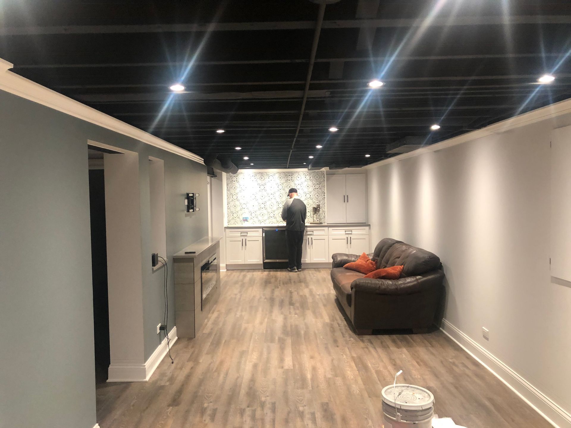 A man is standing in a living room with a couch.