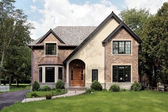 A large brick house with a driveway in front of it