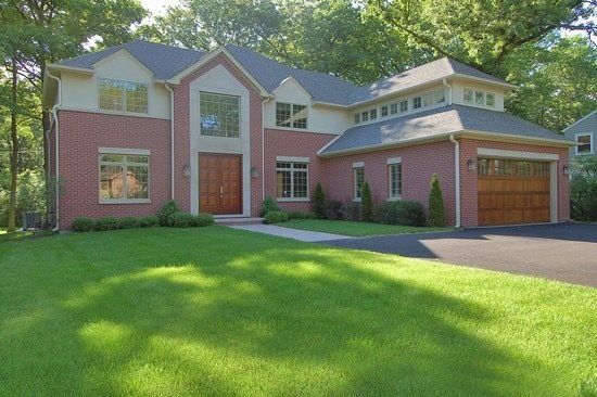 A large red brick house with a wooden garage door