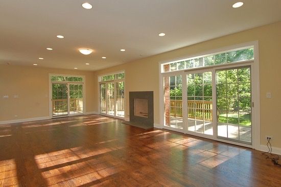 An empty living room with hardwood floors and a fireplace.