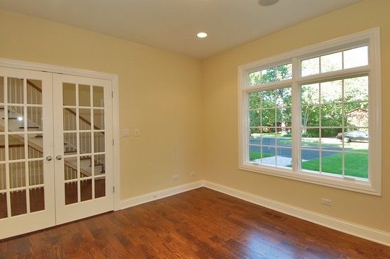 An empty room with hardwood floors and french doors
