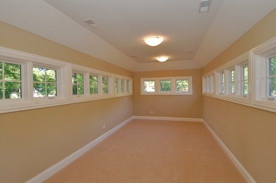 An empty room with lots of windows and a ceiling light