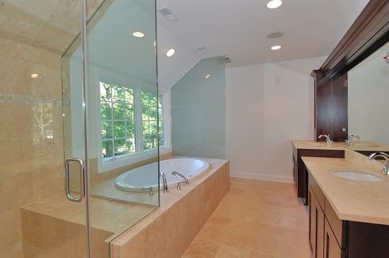 A bathroom with a tub , sink , and walk in shower