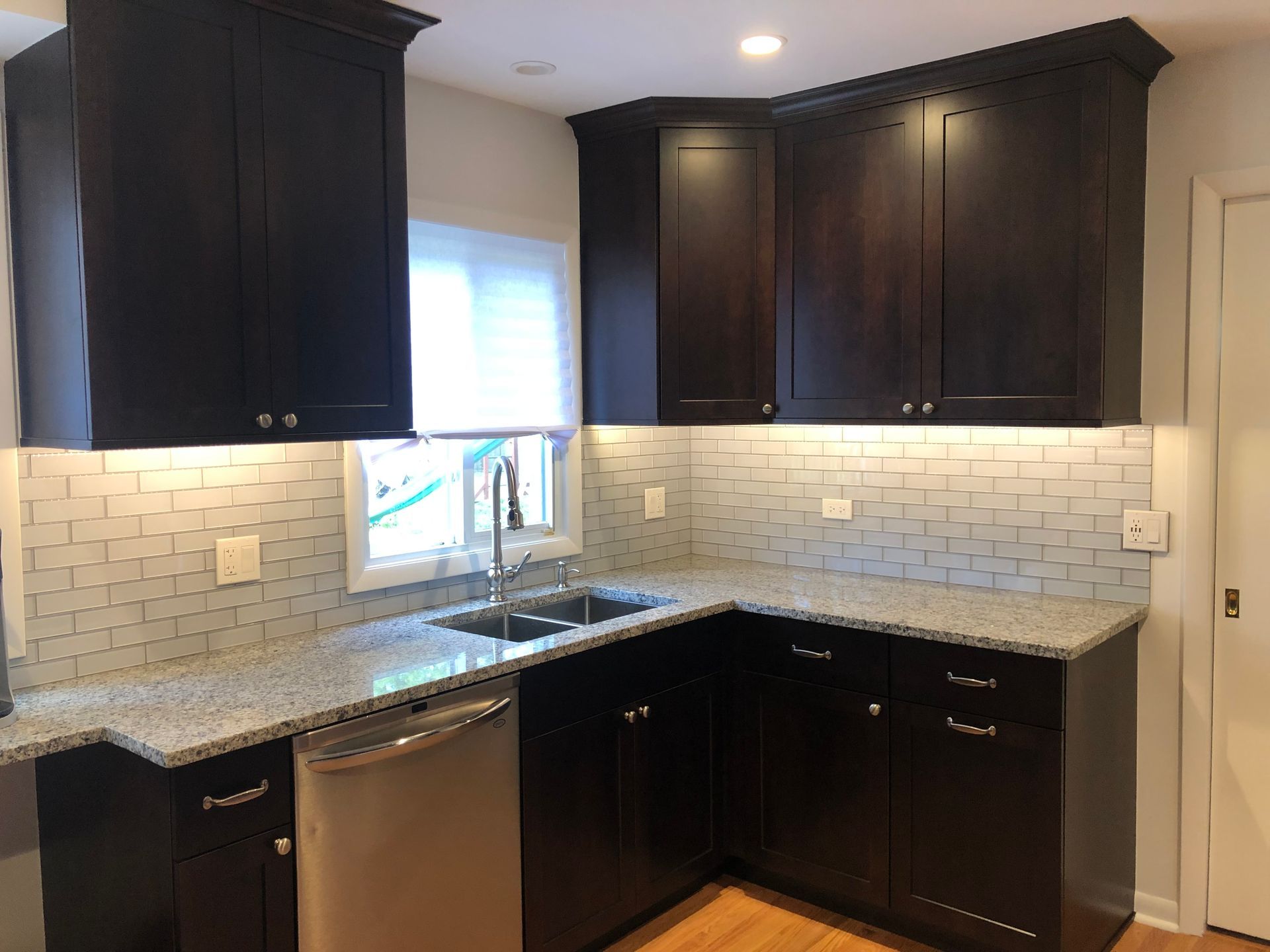 A kitchen with black cabinets and granite counter tops