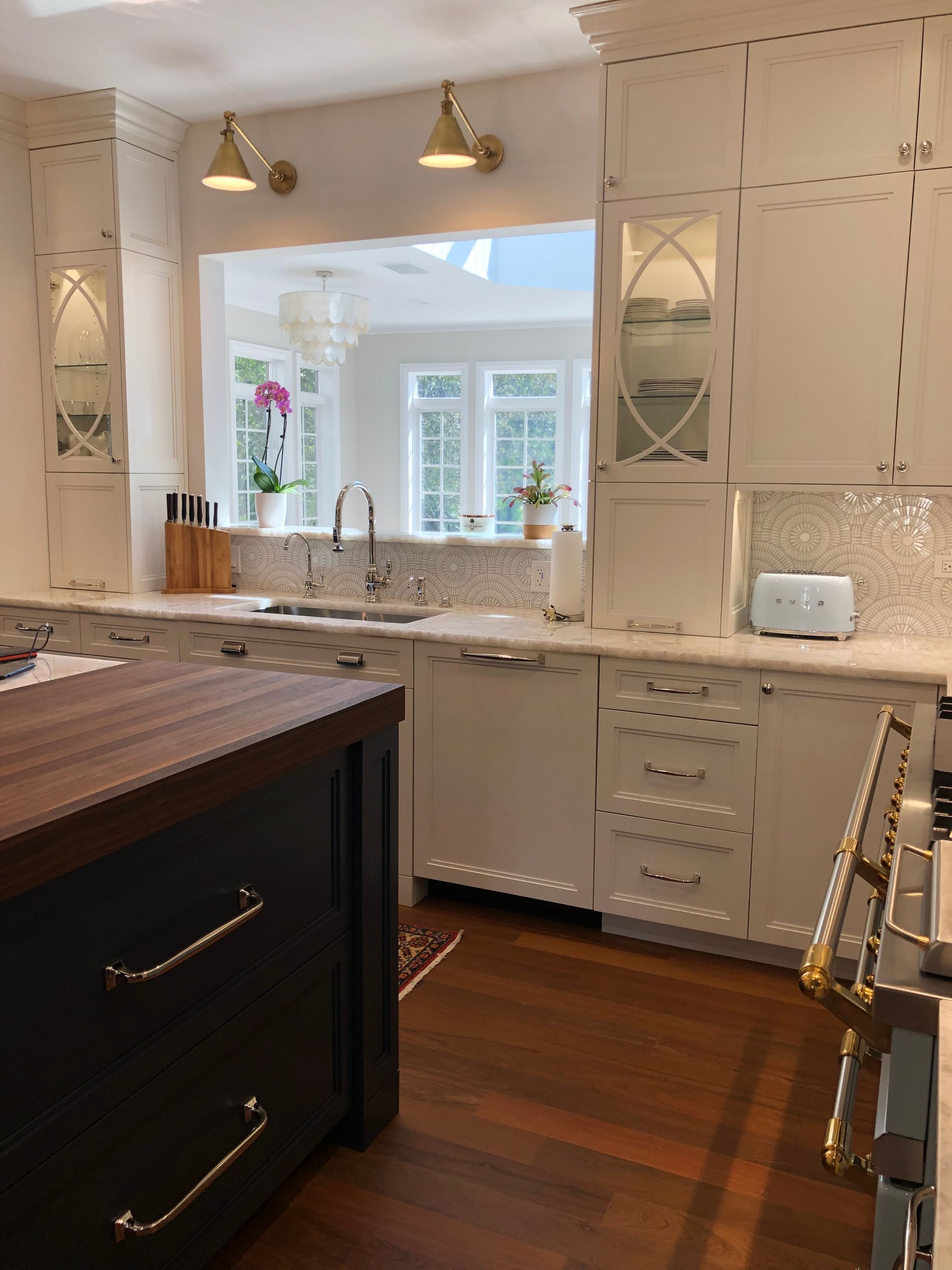 A kitchen with white cabinets and a wooden counter top