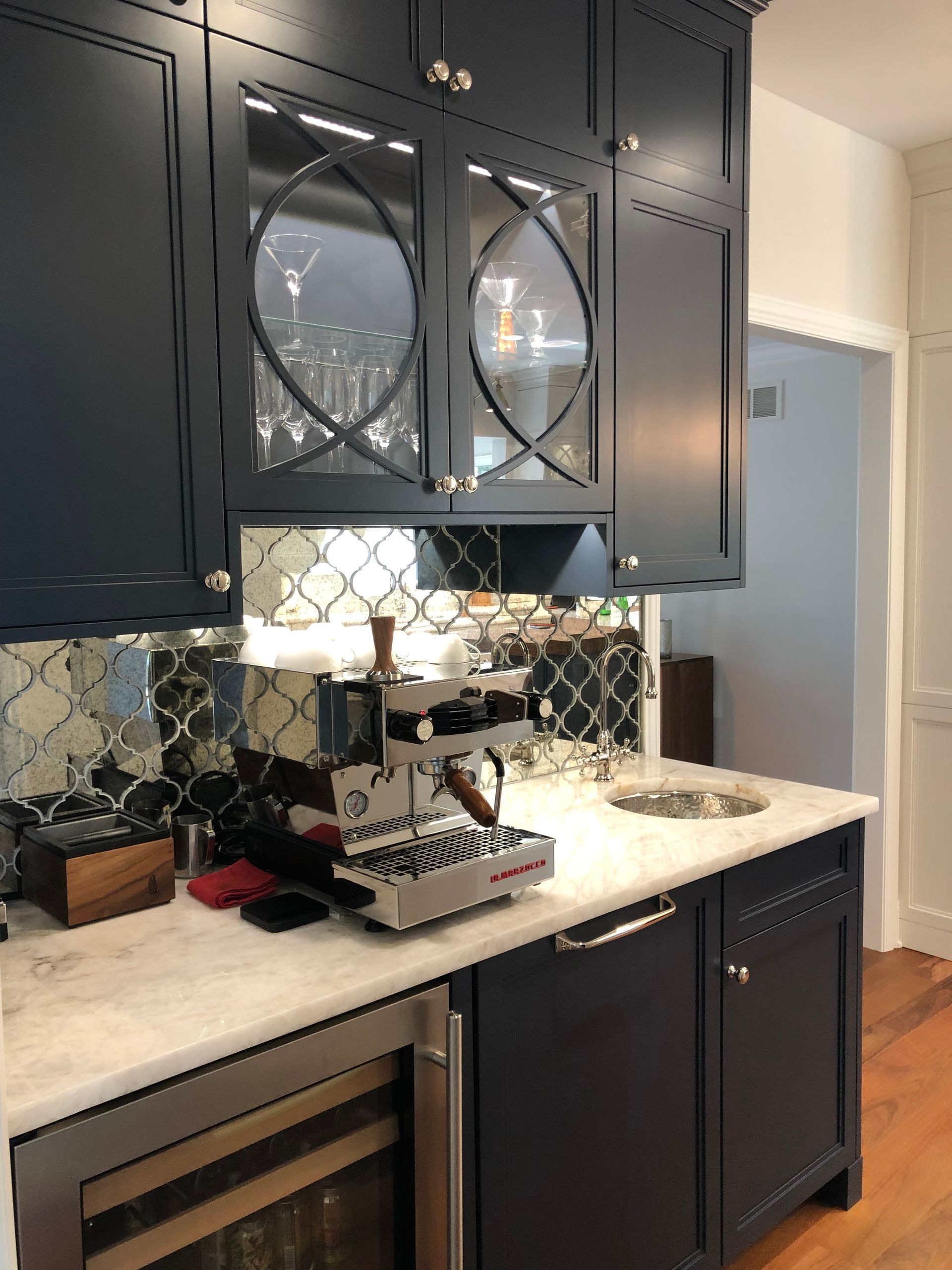 A kitchen with blue cabinets and a coffee maker on the counter.