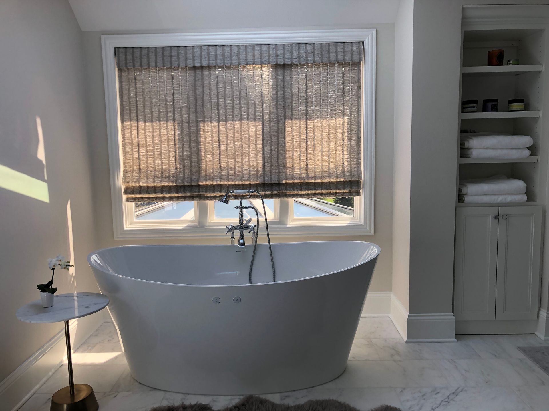 A bathroom with a bathtub and a window.