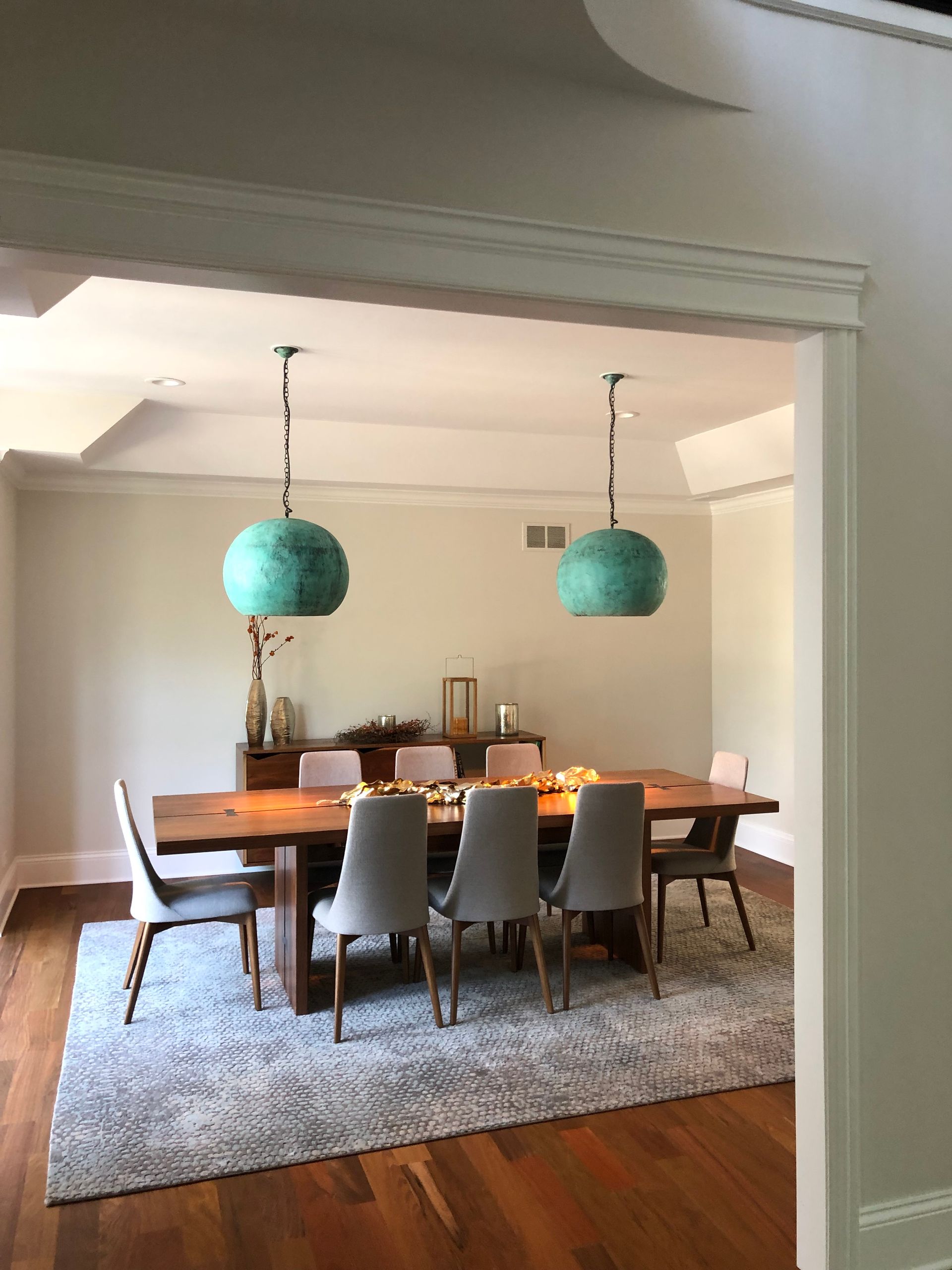 A dining room with a table and chairs and a rug.