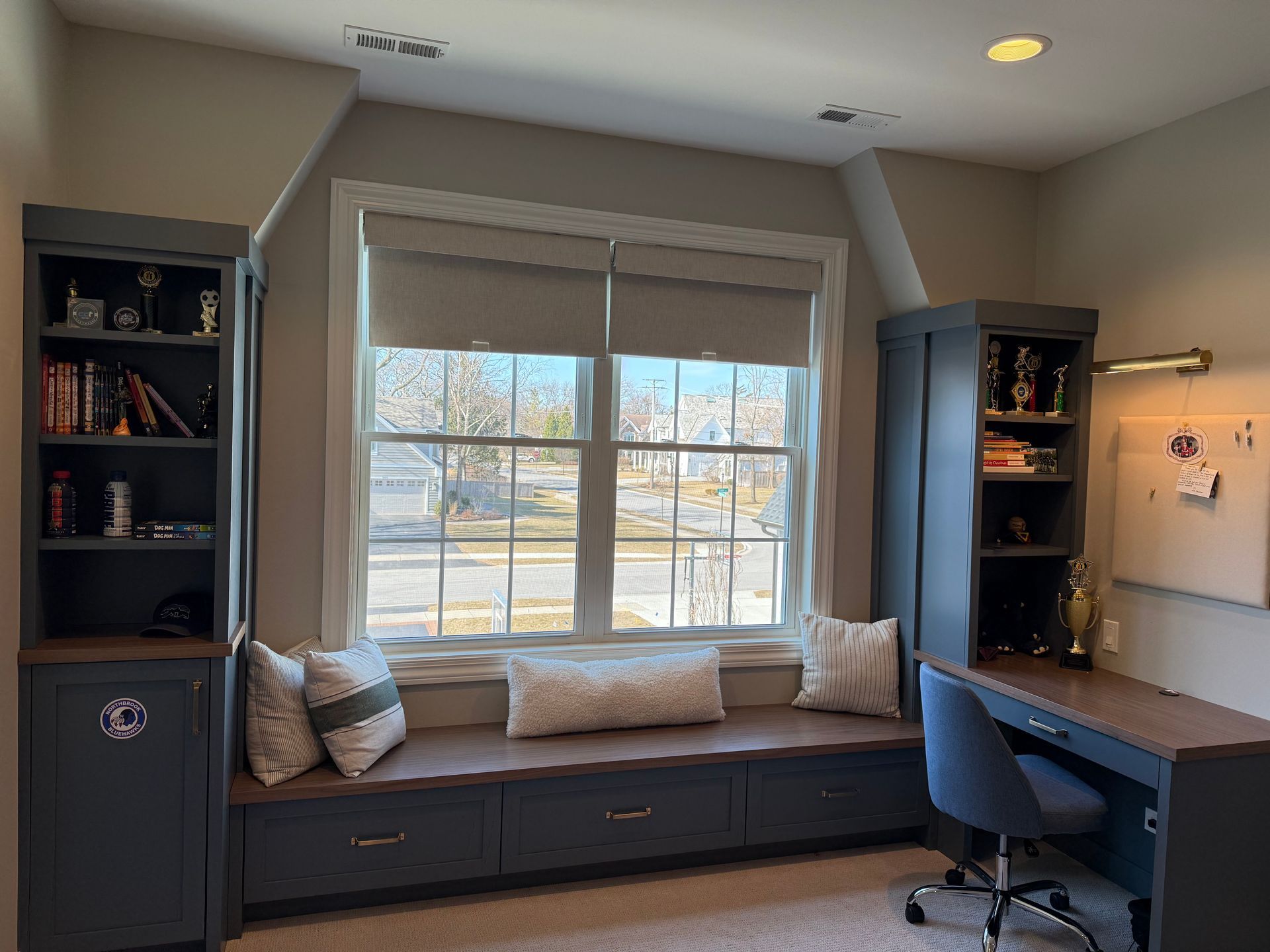 A room with a window seat and a desk.