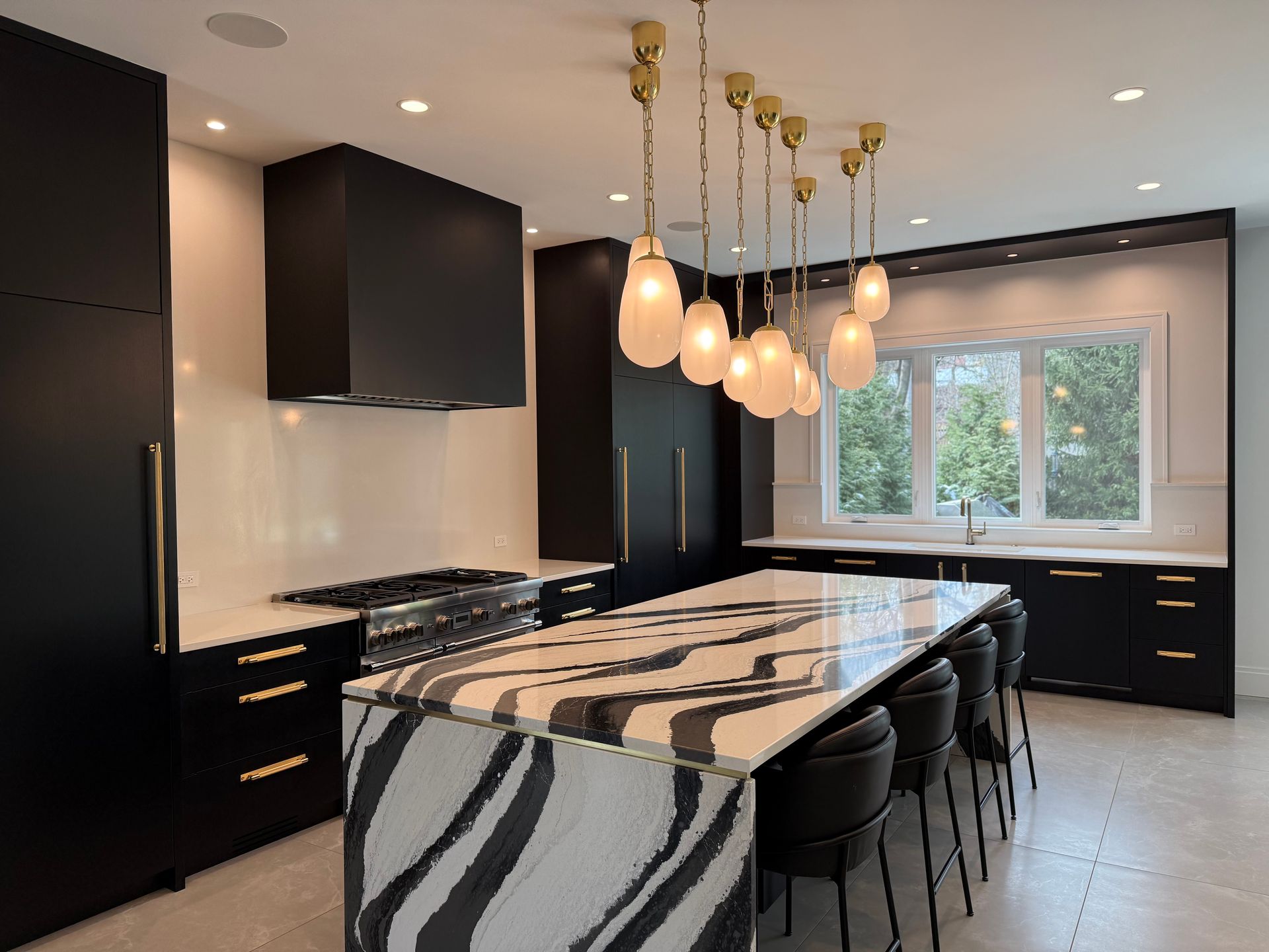 A kitchen with black cabinets and a large island with a zebra print counter top.