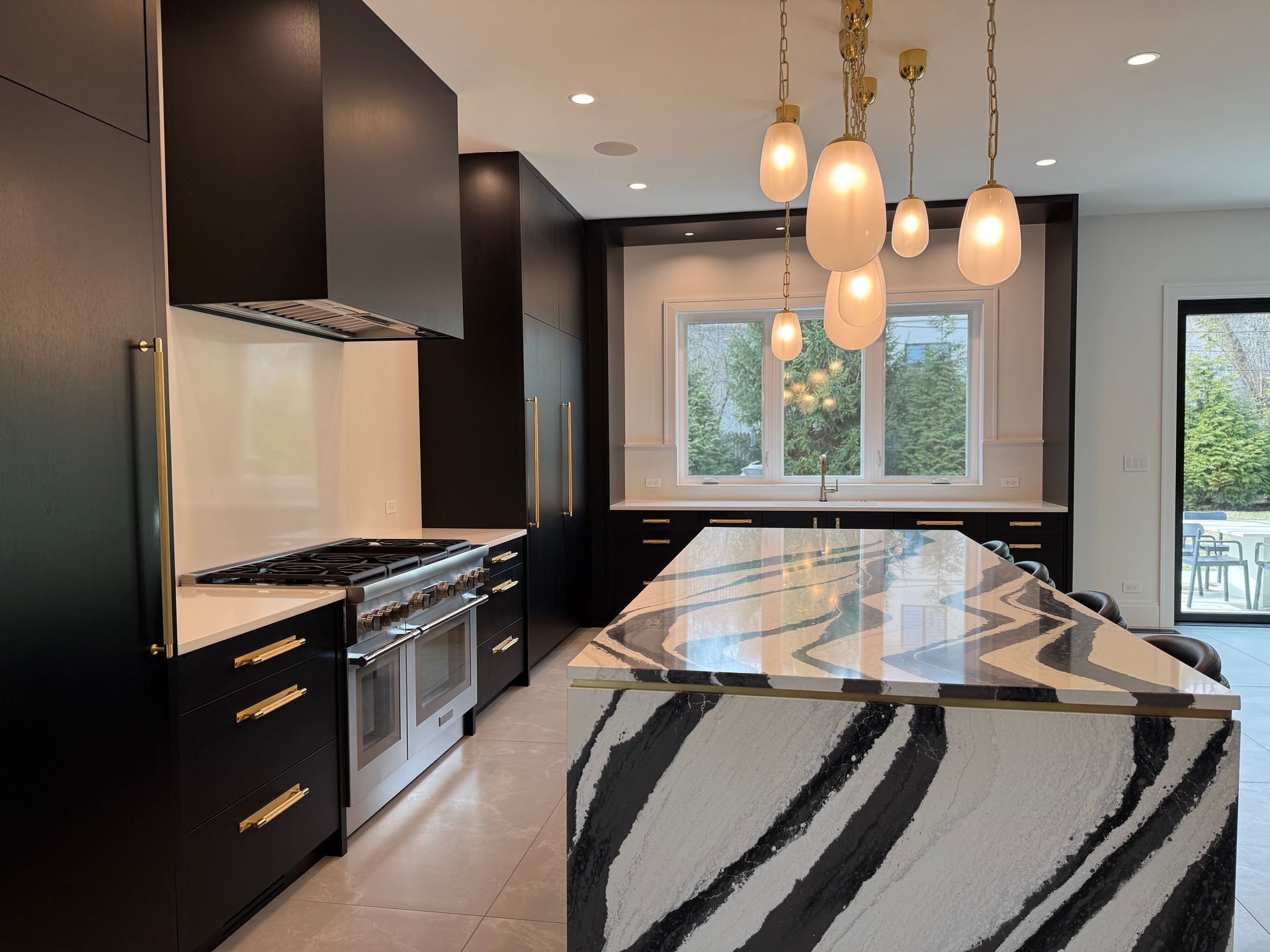 A kitchen with black cabinets and a large island with a zebra print counter top.