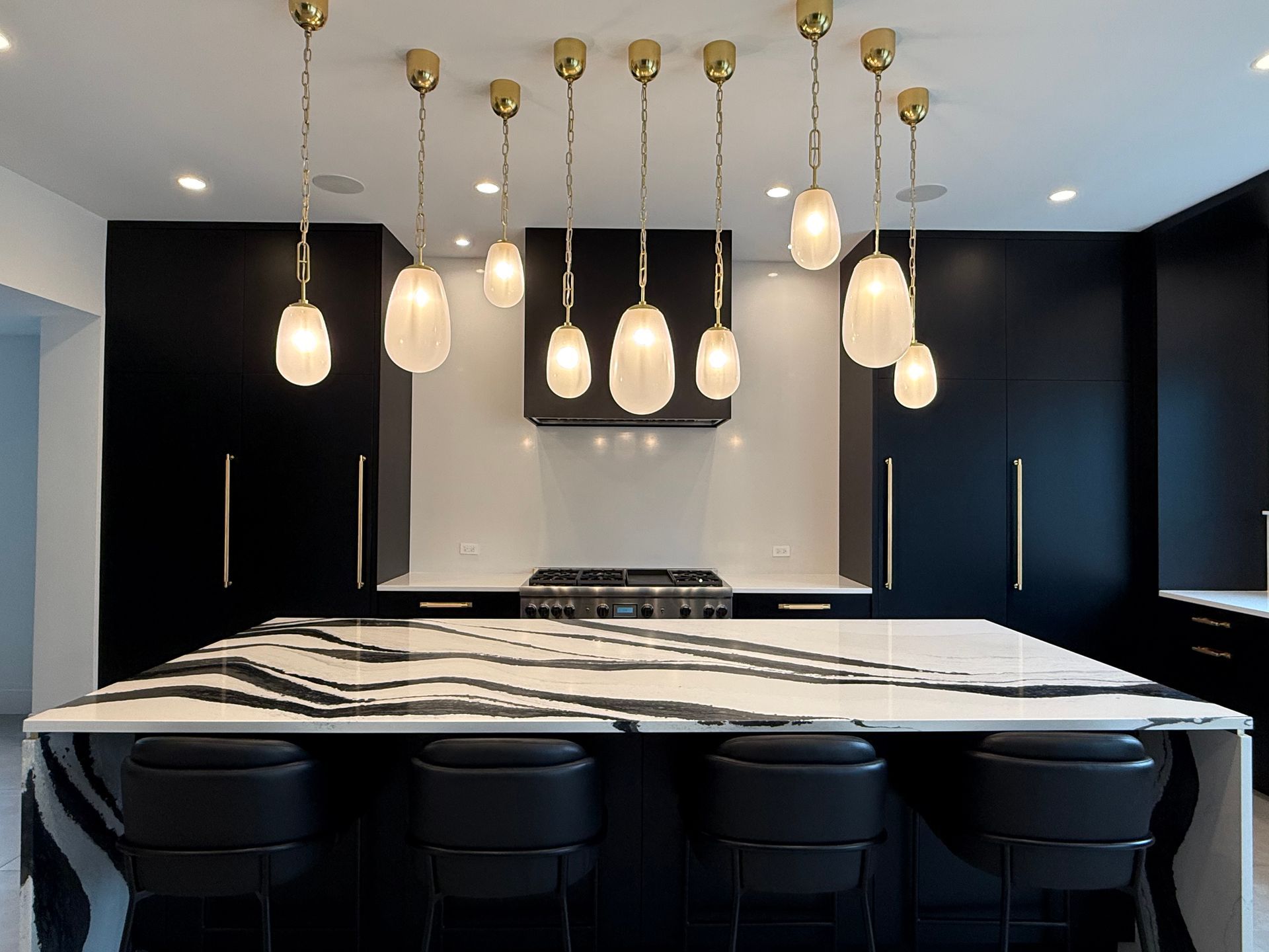 A kitchen with black and white cabinets and a large island.