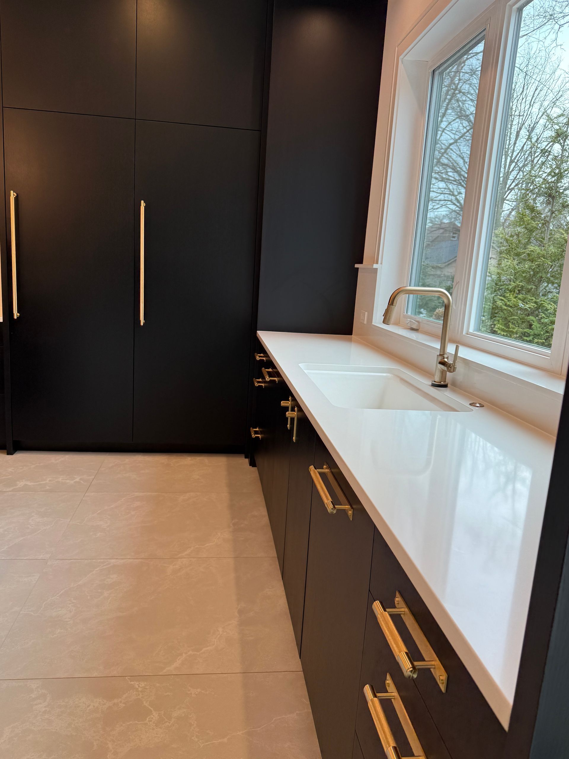 A kitchen with black cabinets and white counter tops