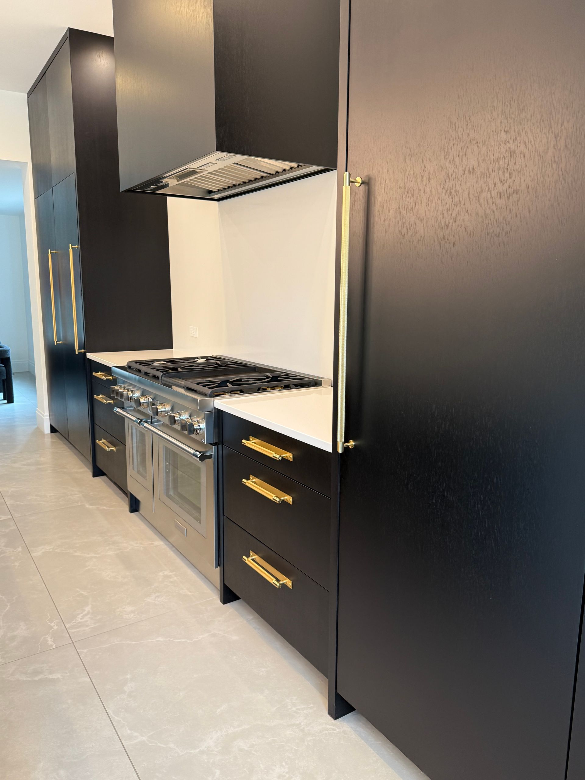 A kitchen with black cabinets and stainless steel appliances.
