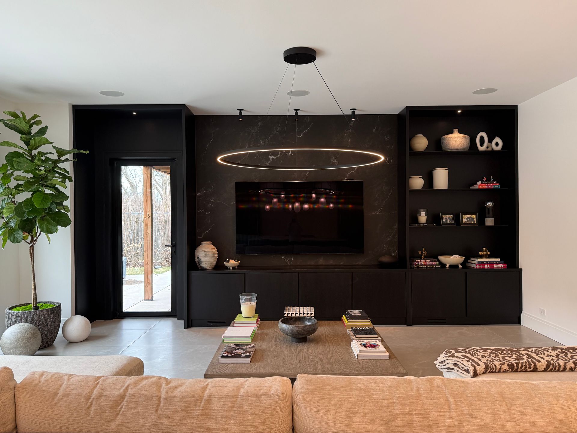A living room with a couch , table , television and shelves.