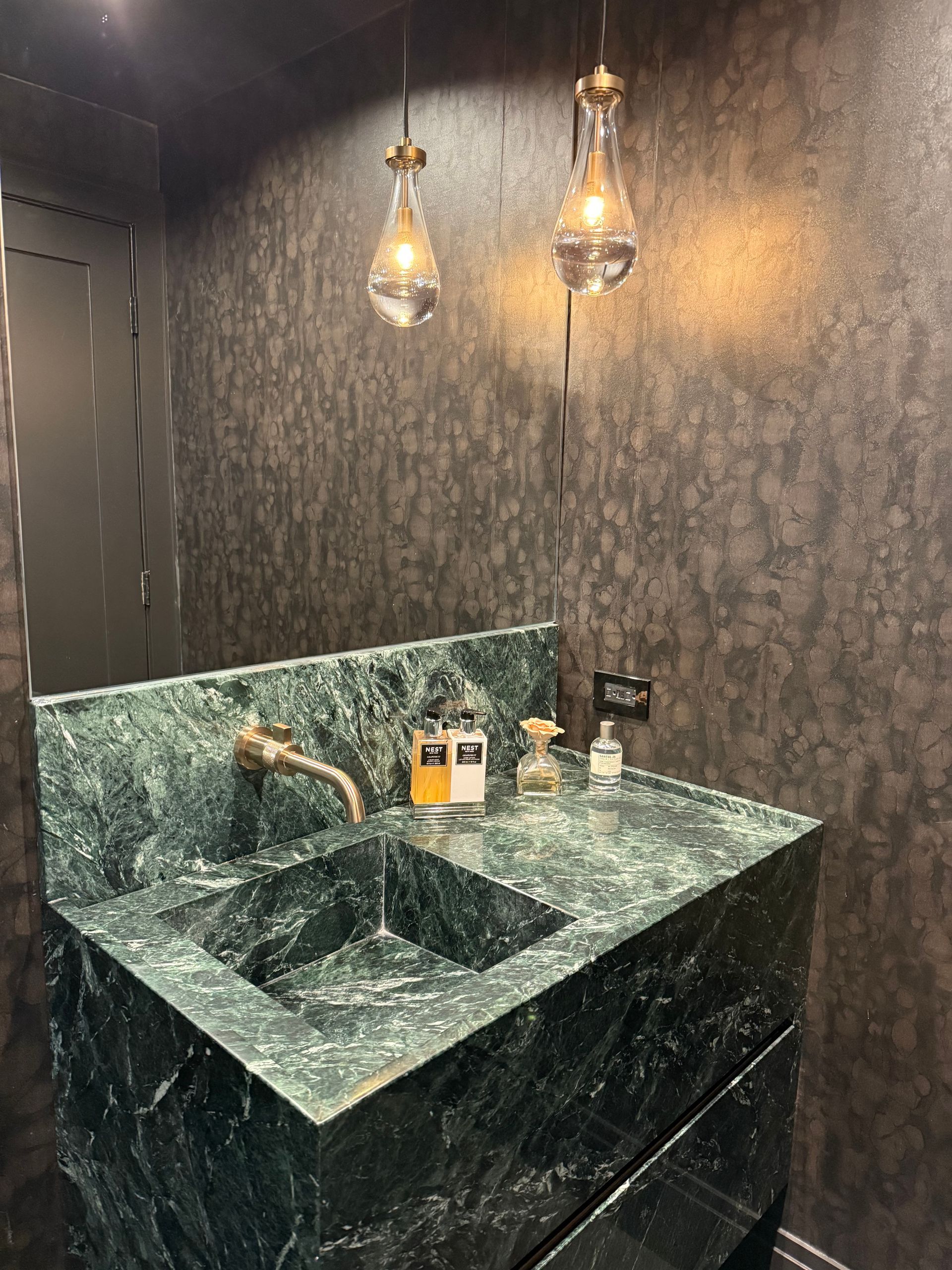 A bathroom with a green sink and a mirror.