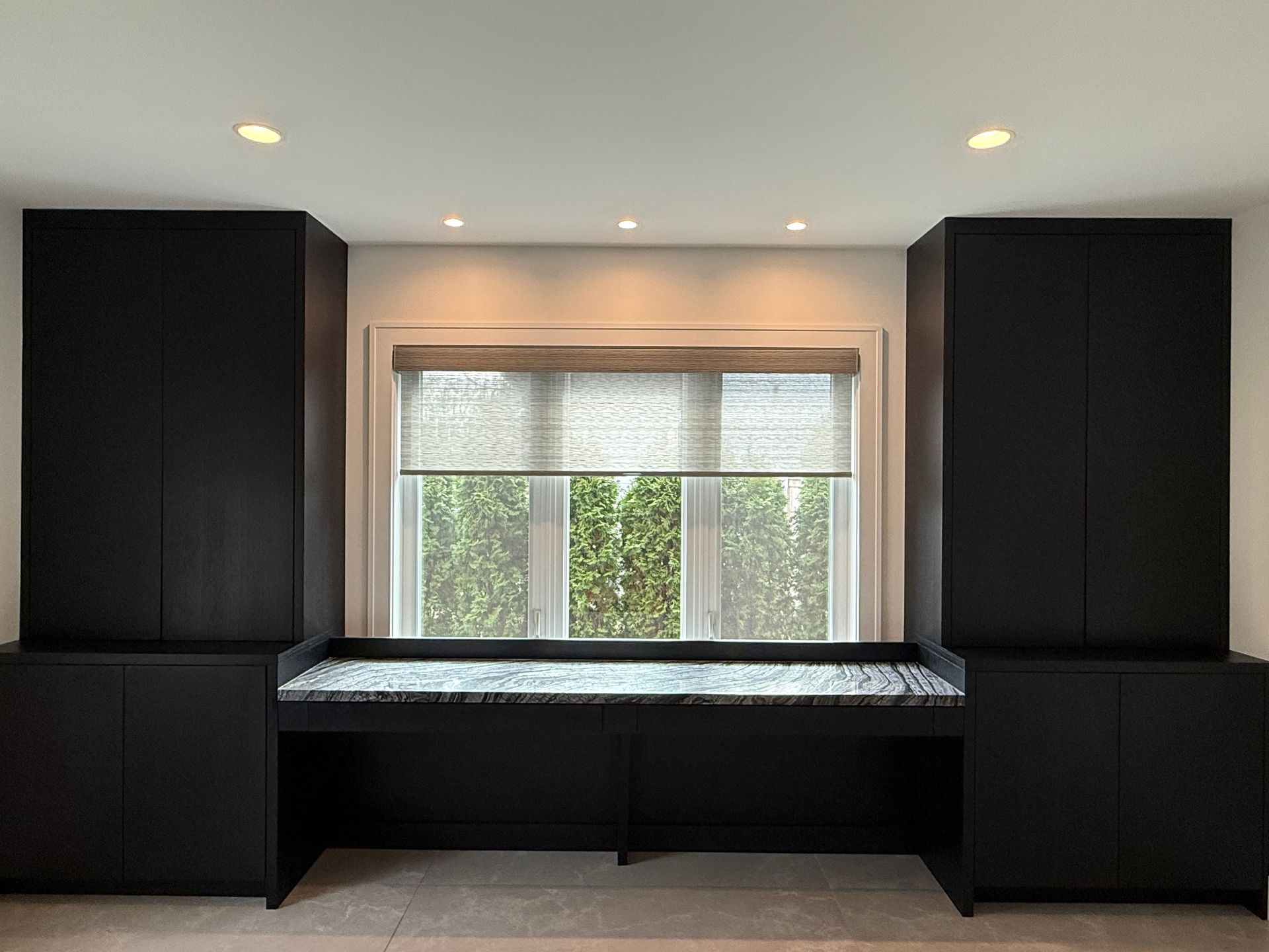 A room with a large window and a desk in front of it.