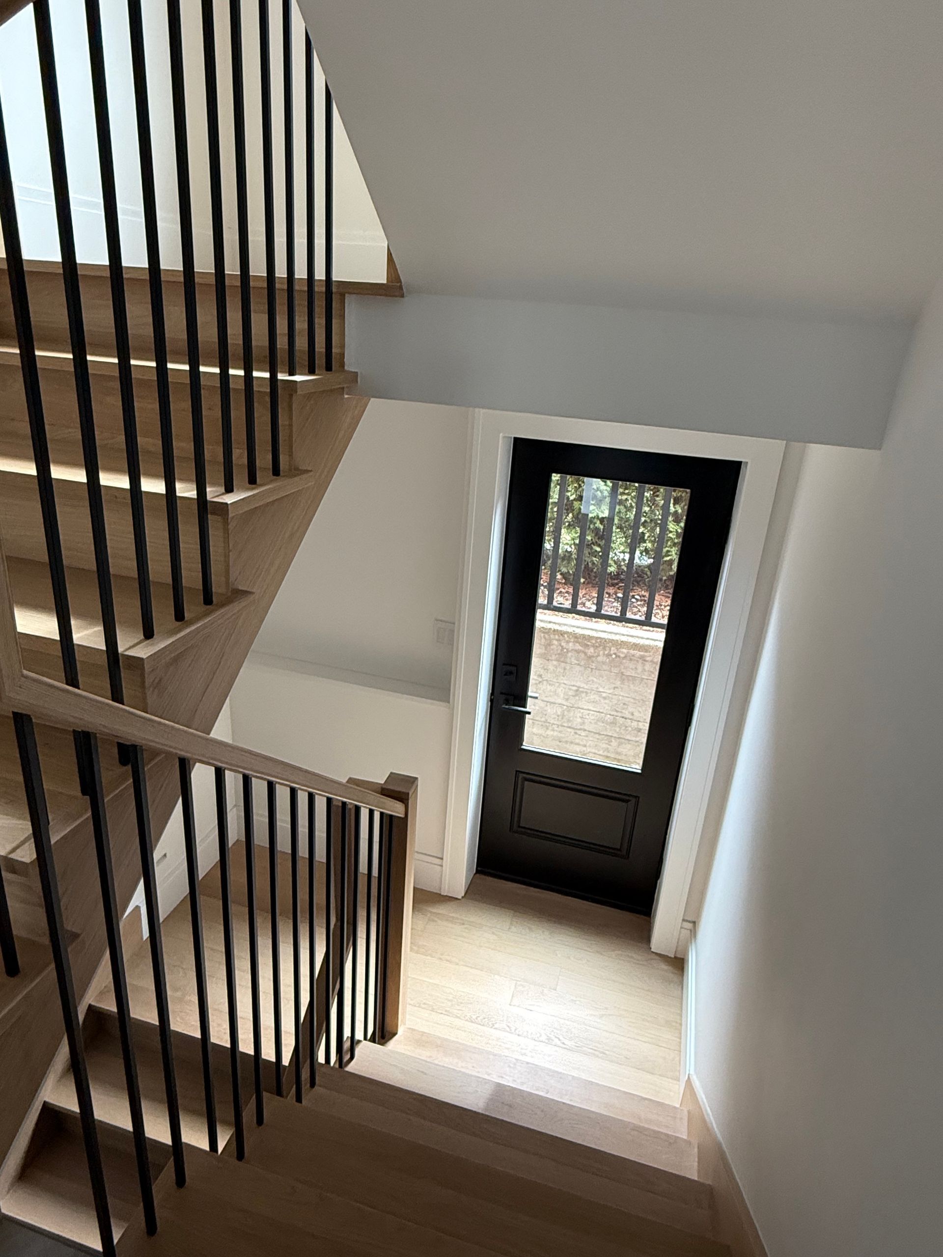 A view of a staircase leading up to a door in a house.