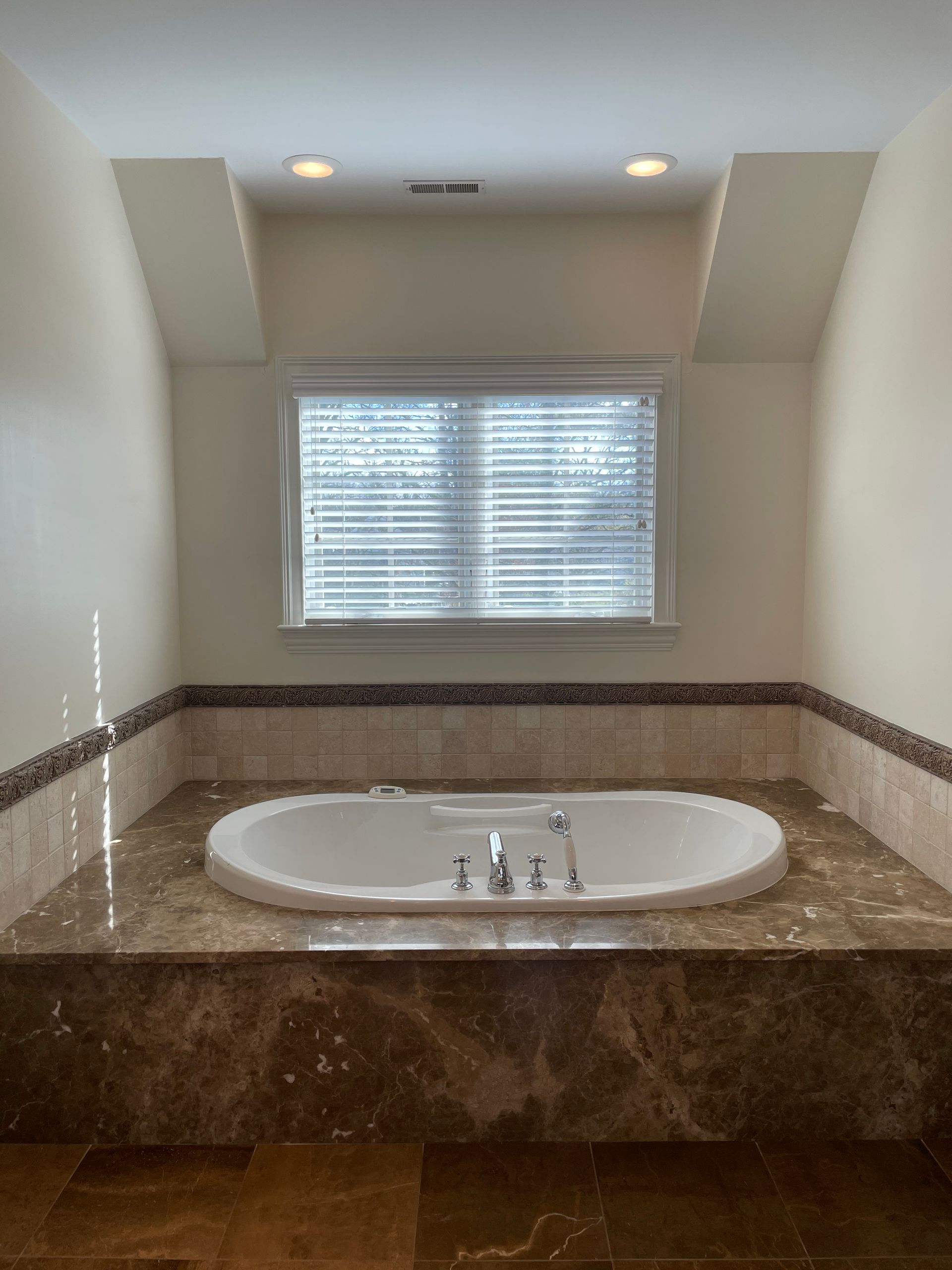 A bathroom with a jacuzzi tub and a window.