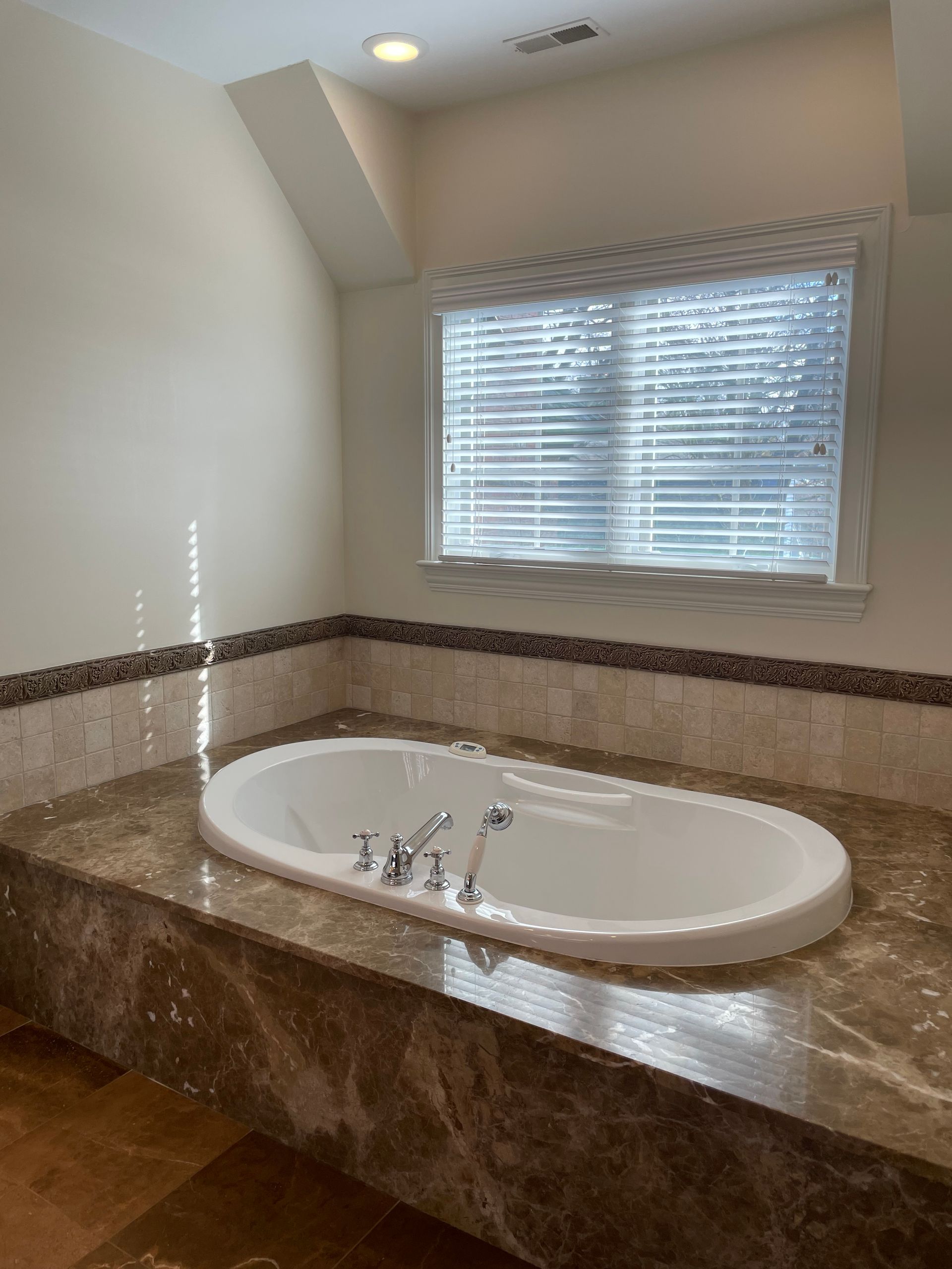 A bathroom with a jacuzzi tub and a window.