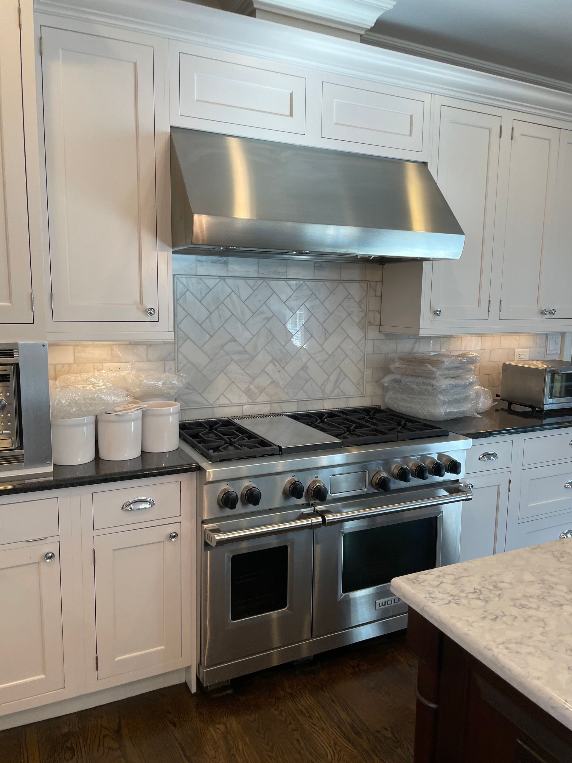 A kitchen with stainless steel appliances and white cabinets