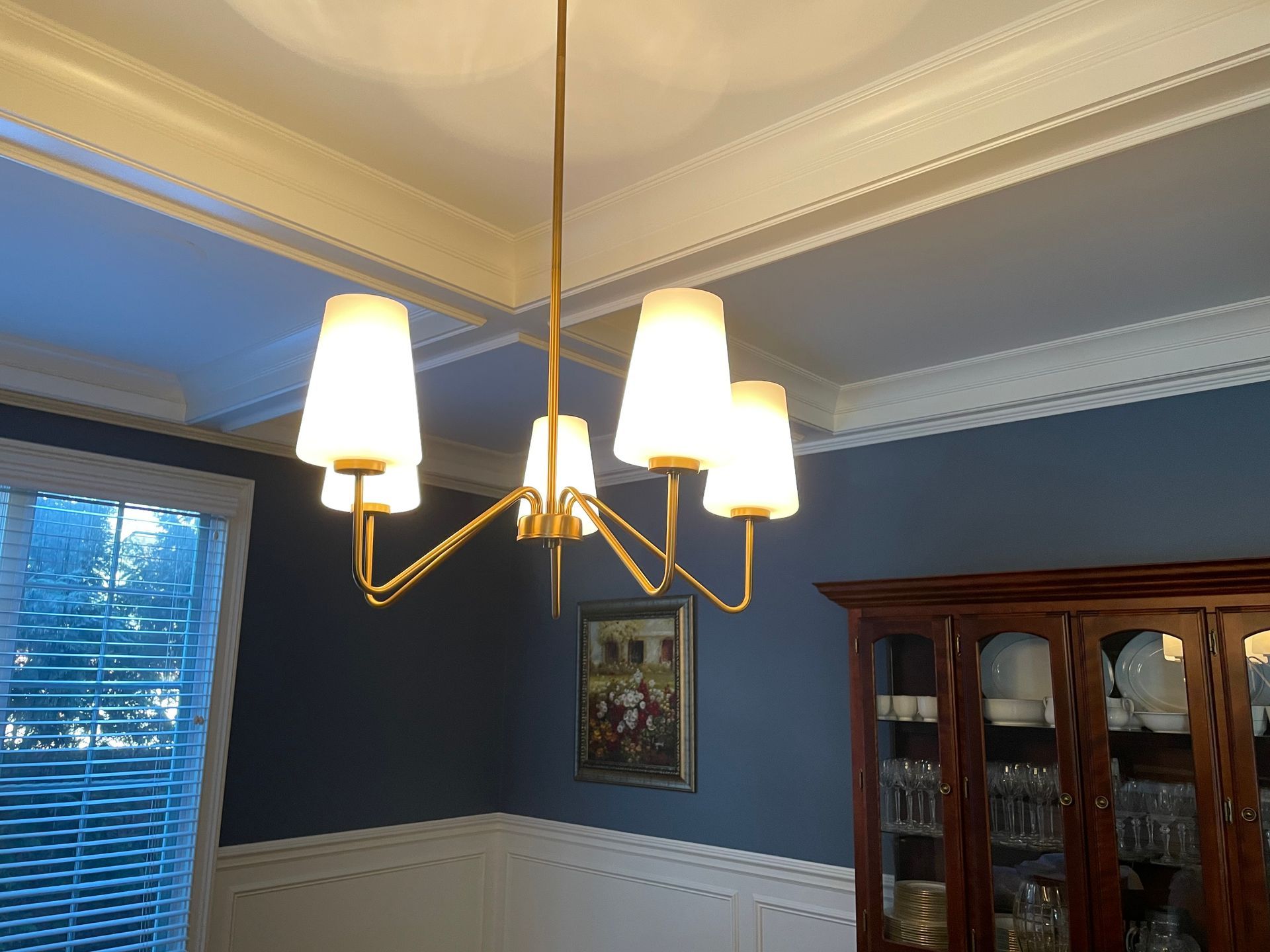 A dining room with a chandelier hanging from the ceiling