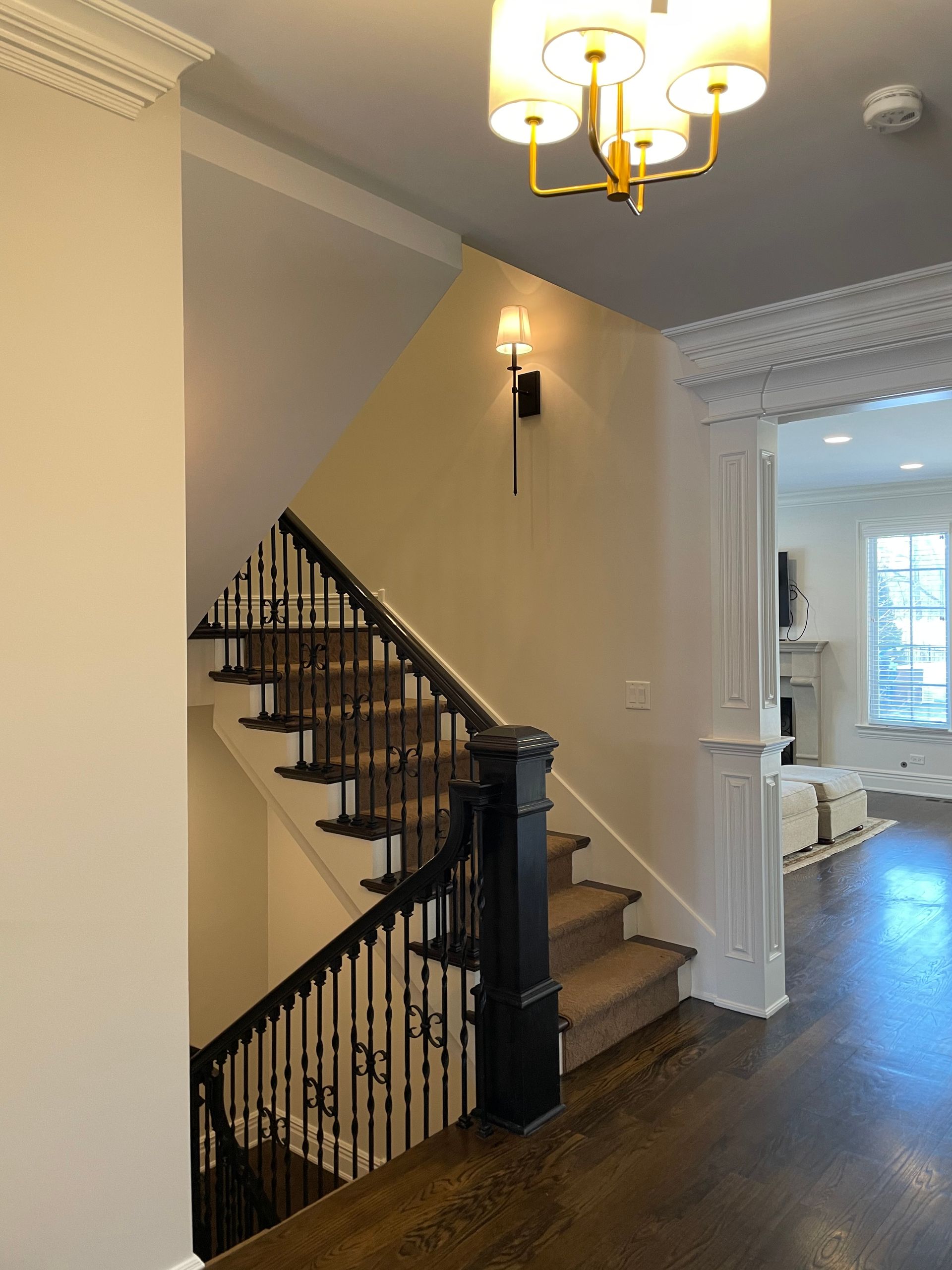 A staircase in a house with a chandelier hanging from the ceiling