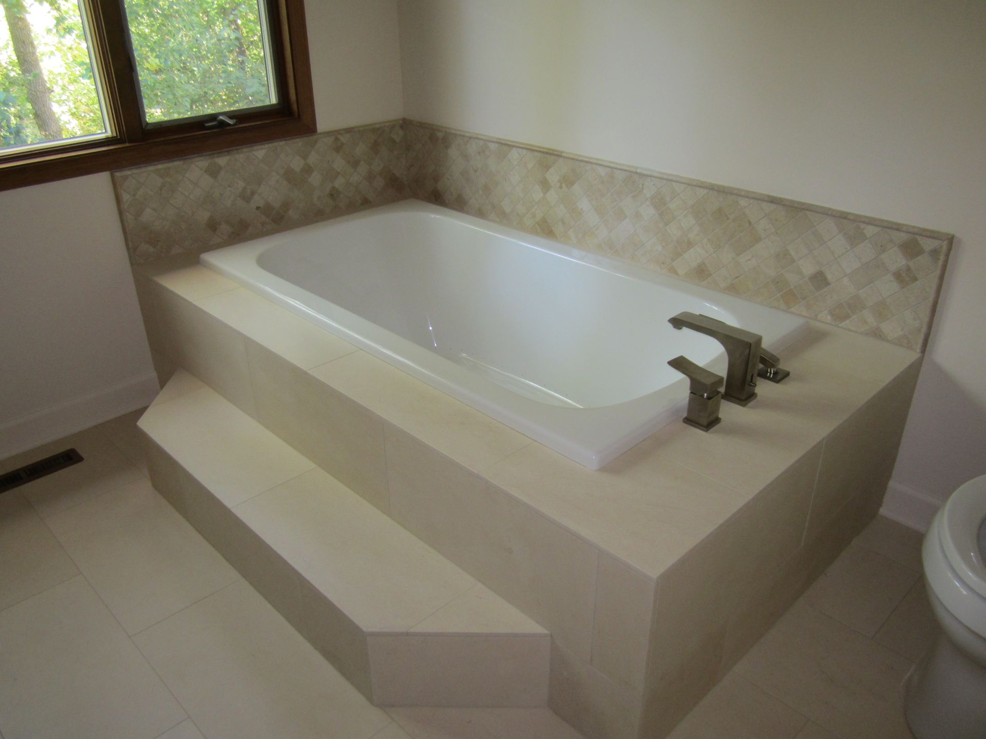 A bathtub in a bathroom next to a toilet