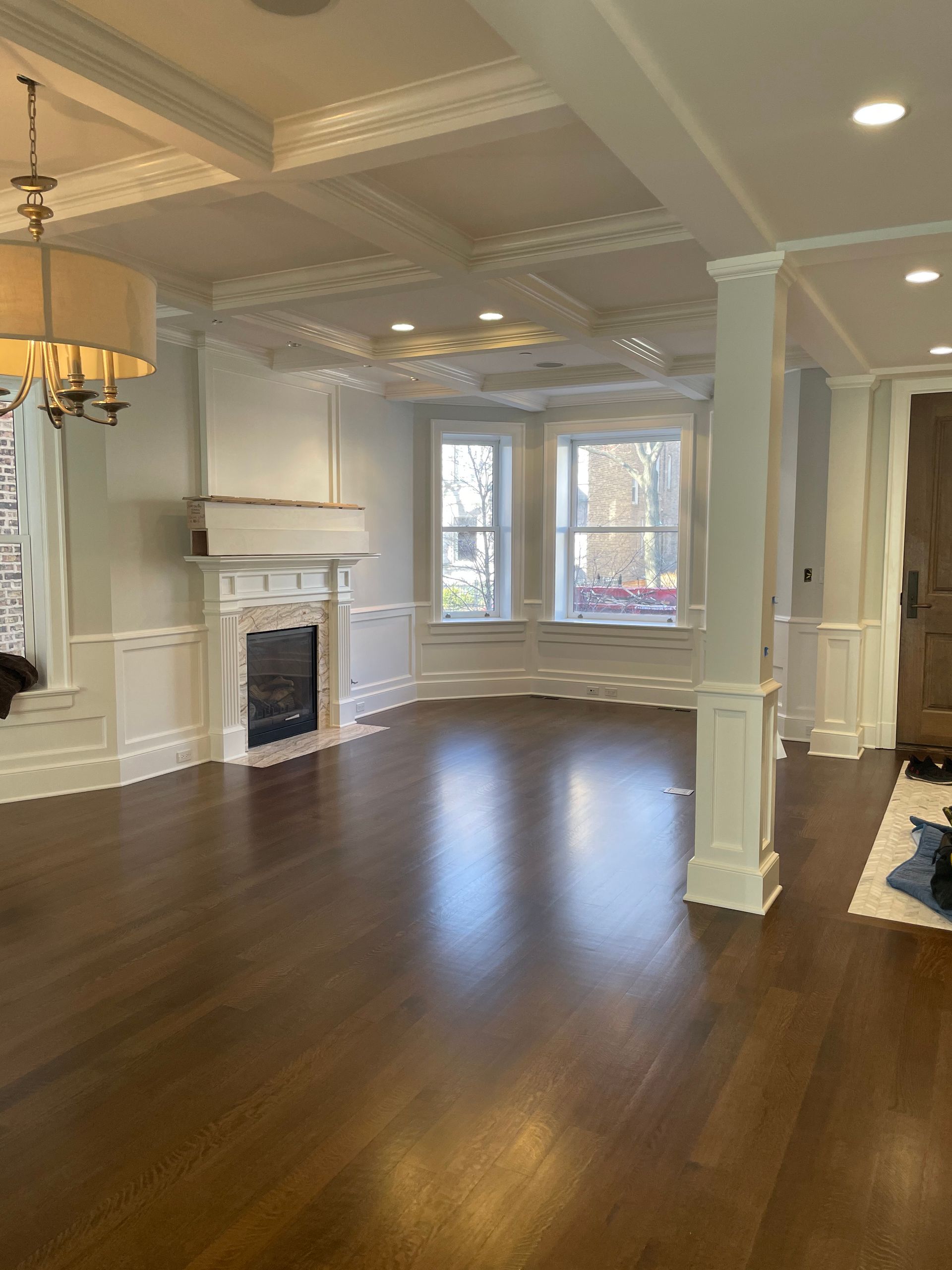 An empty living room with hardwood floors and a fireplace.