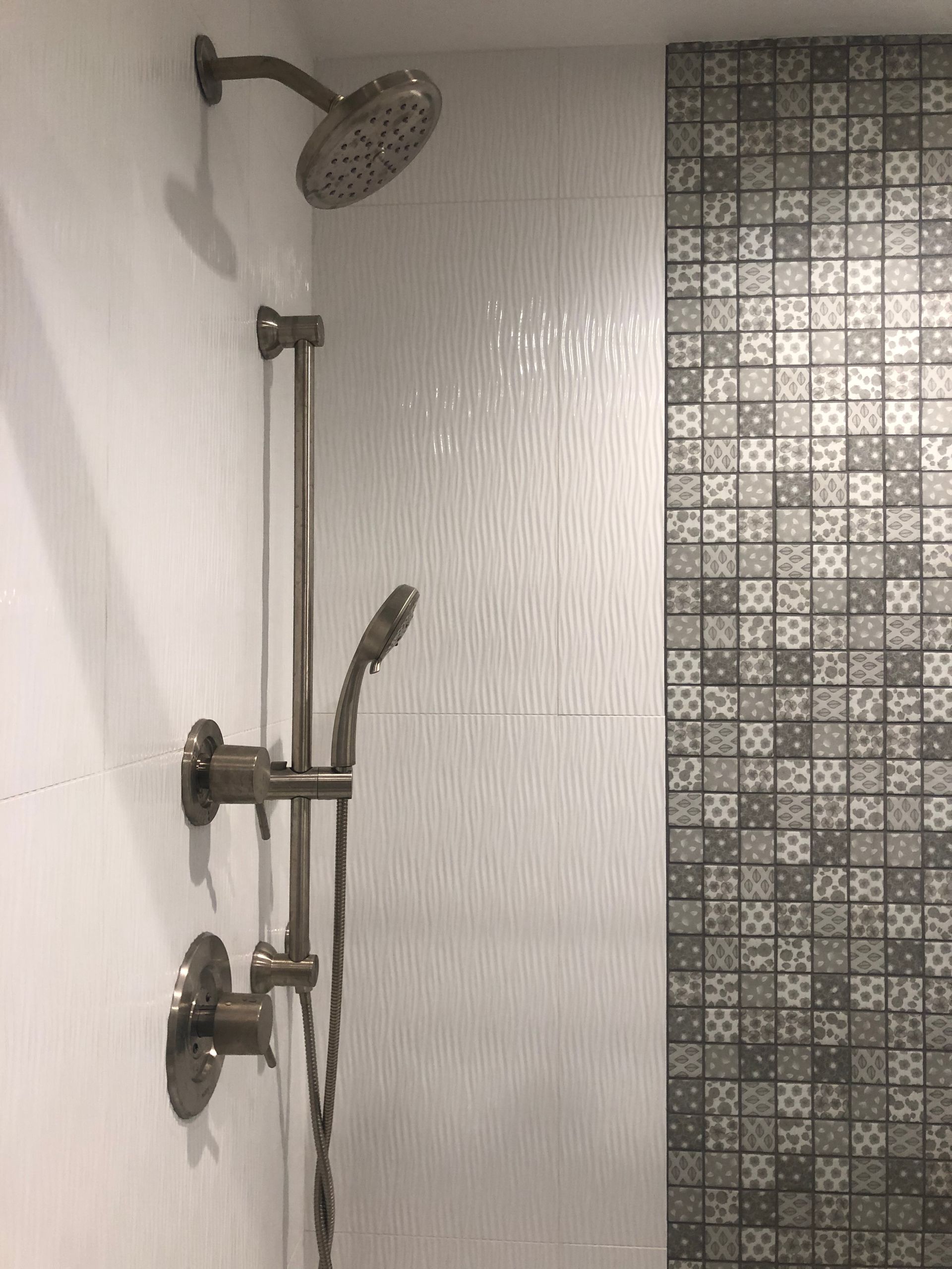 A shower with a shower head and a handheld shower head.