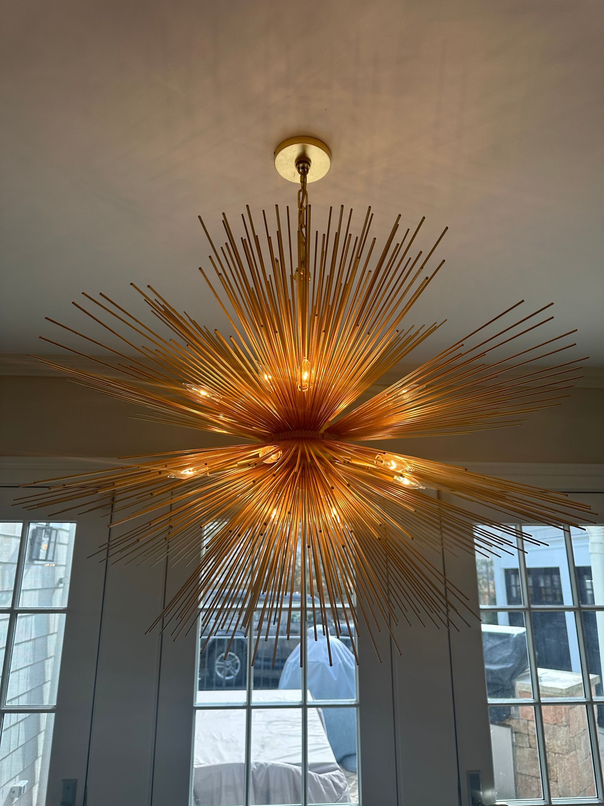 A large gold chandelier is hanging from the ceiling in a room.