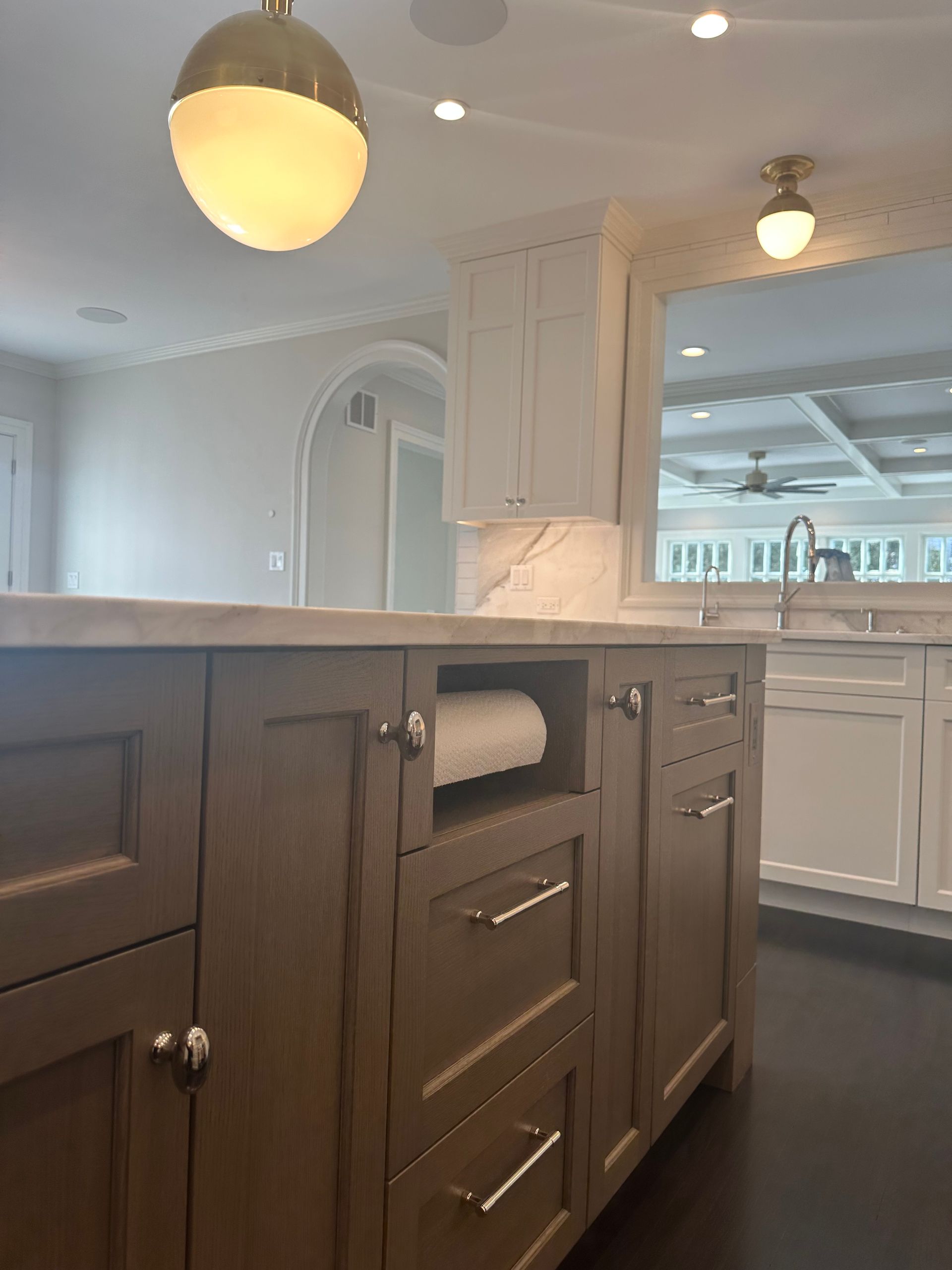 A kitchen with brown cabinets and white cabinets and a sink