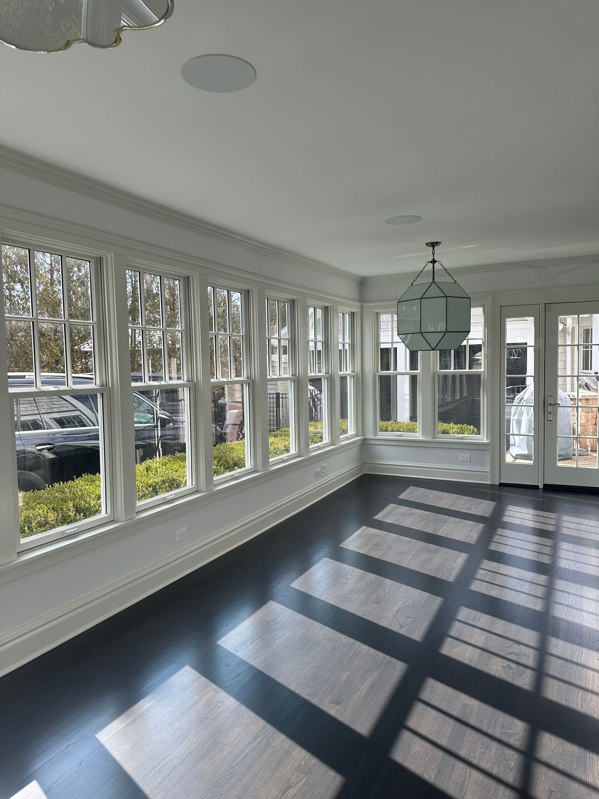 An empty room with a lot of windows and a black floor