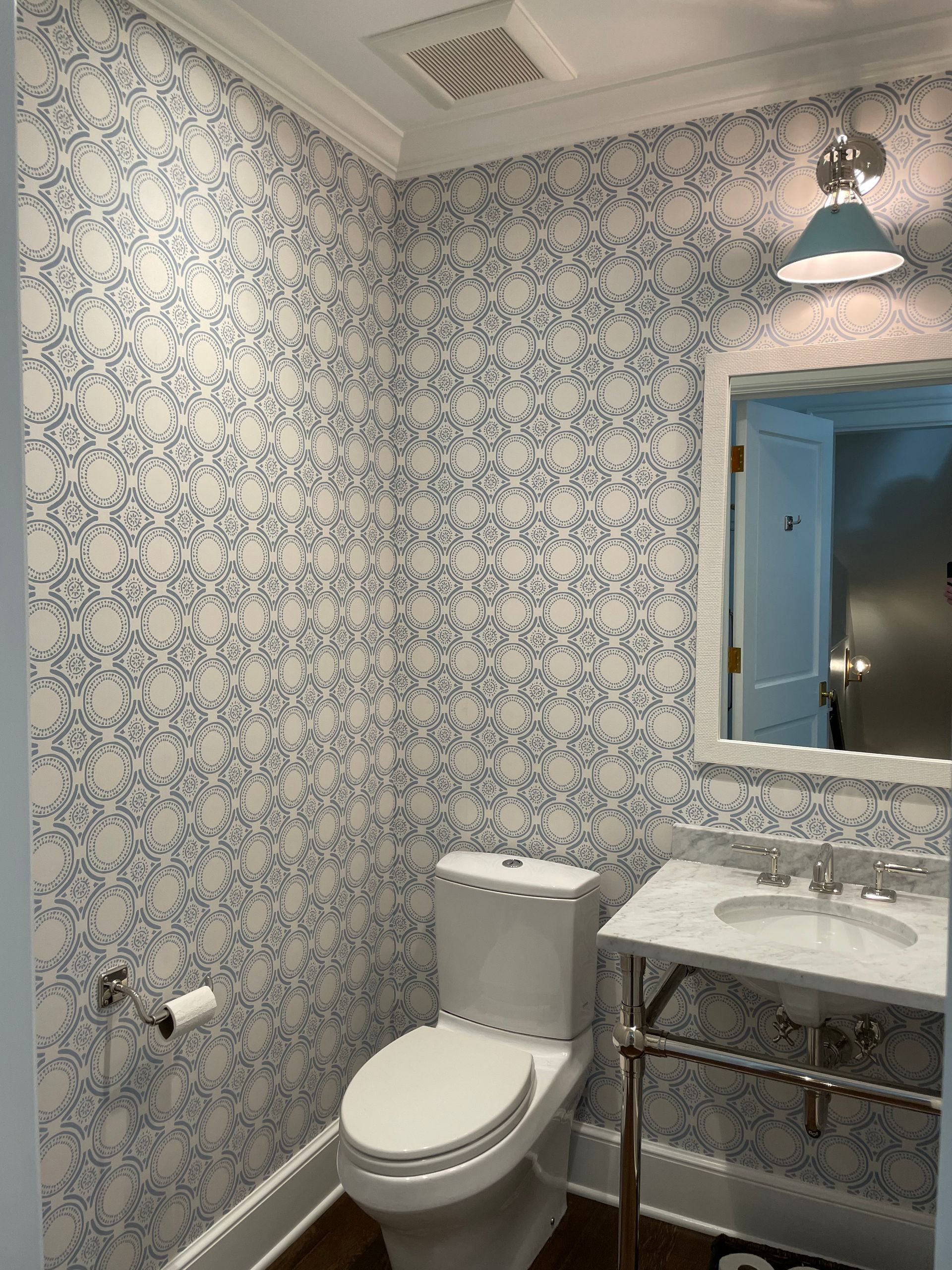 A bathroom with a toilet a sink and a mirror