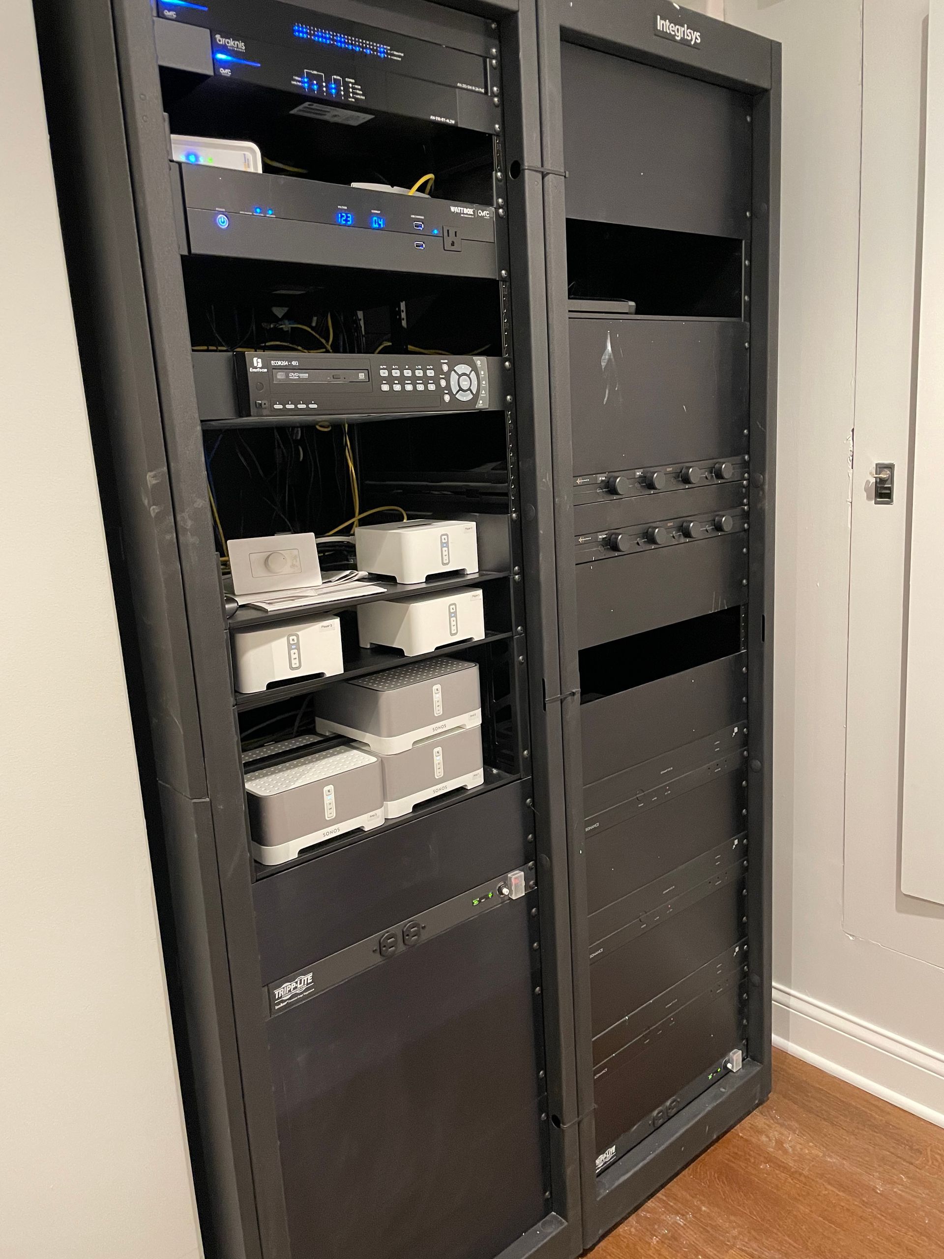 A large black server rack filled with lots of electronic equipment.