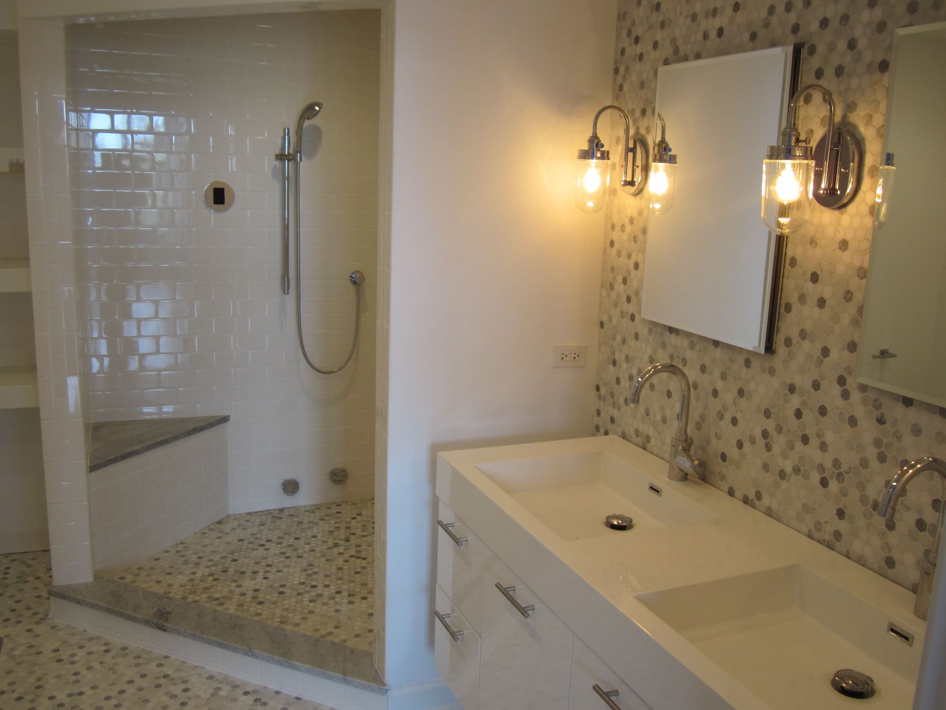 A bathroom with two sinks and a walk in shower