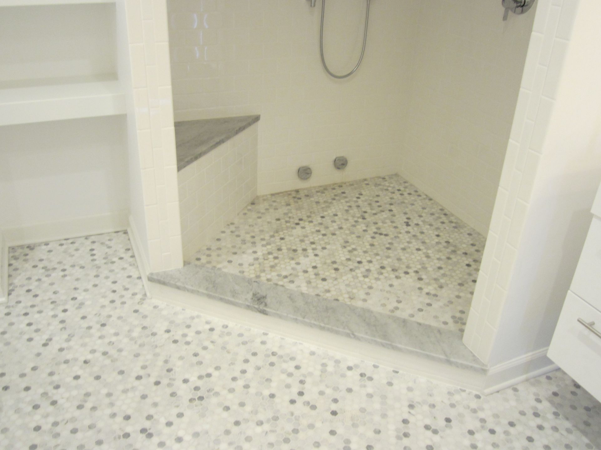 A bathroom with a walk in shower and a tiled floor.